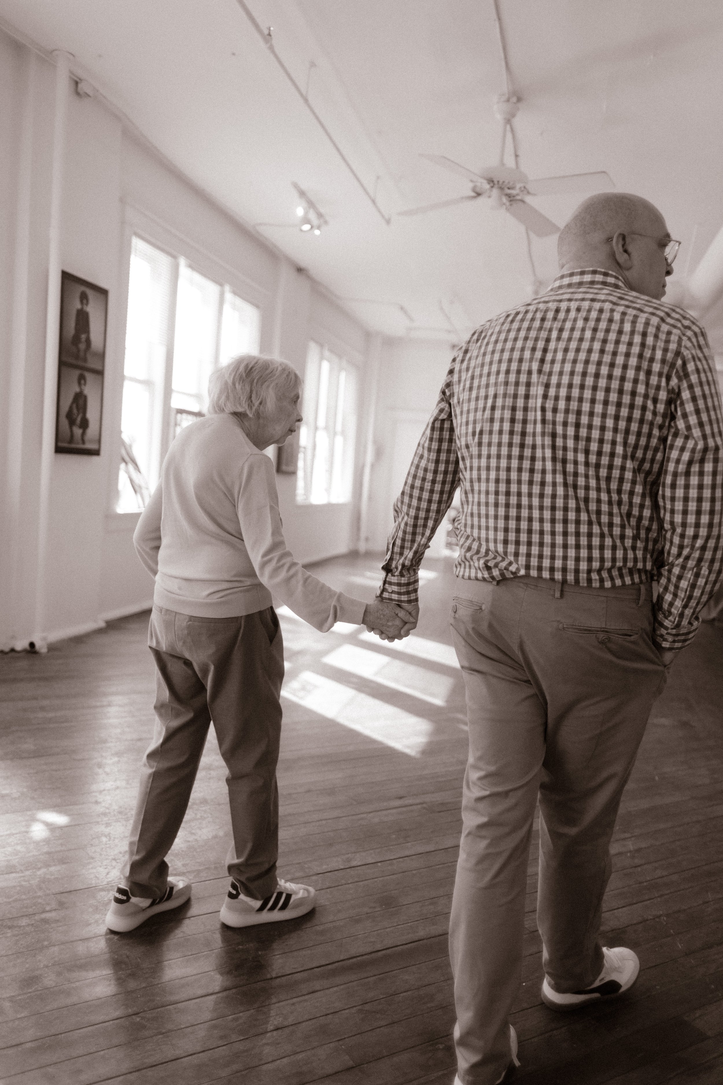 Older couple holding hands, walking through soft morning light at a Tennessee wedding venue