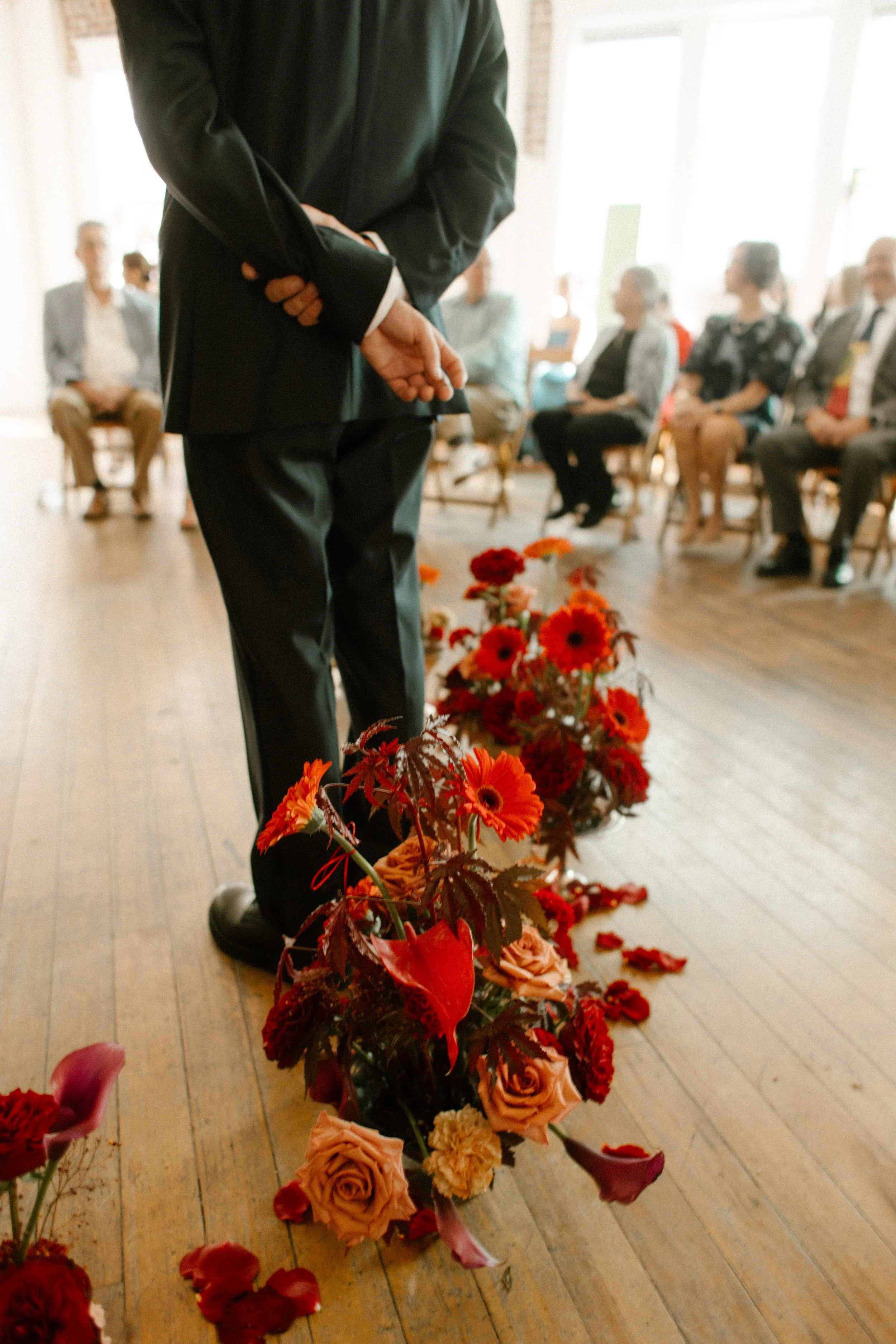 Groom standing quietly among floral arrangements, waiting for the ceremony to start at a Tennessee wedding