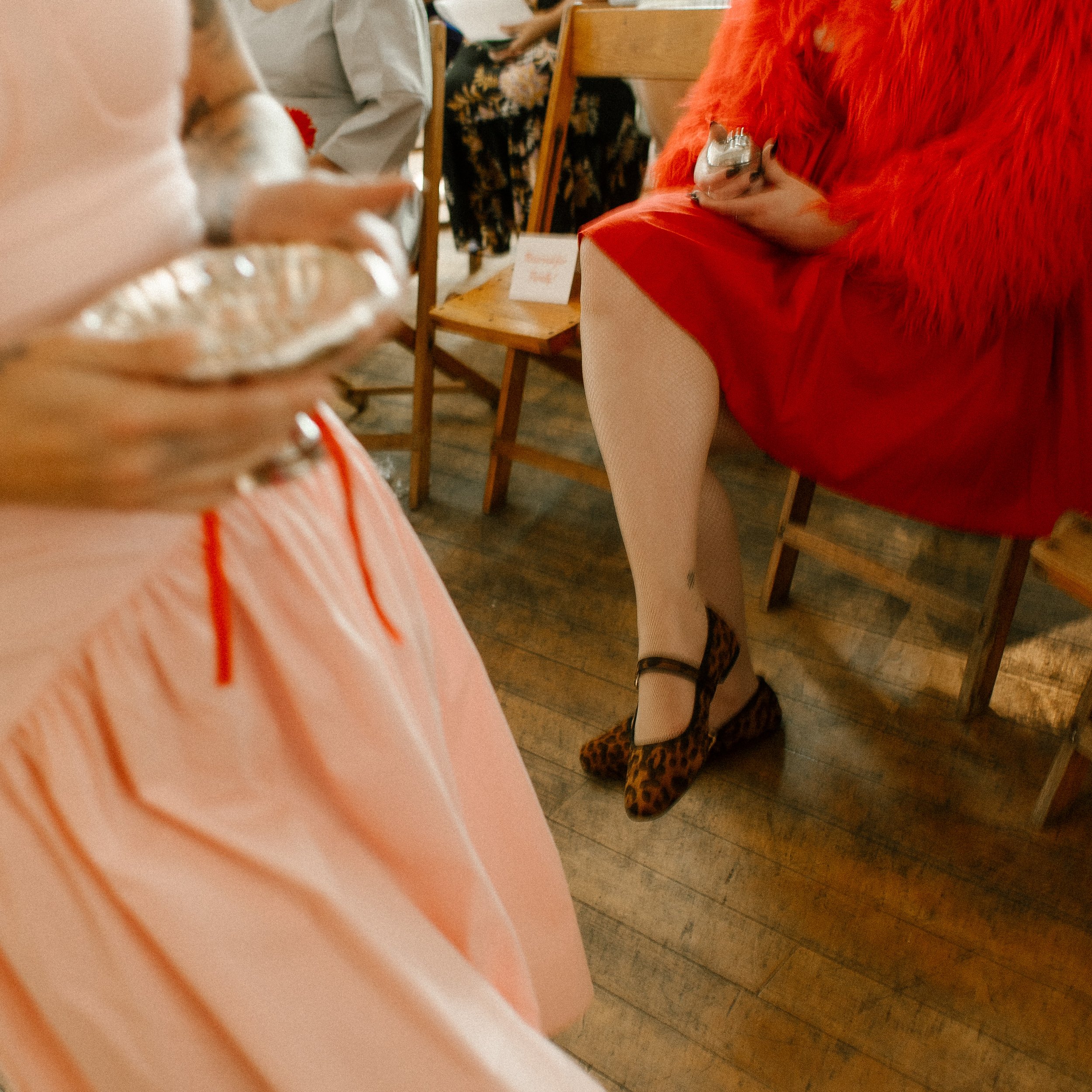 Close-up of guests’ outfits and hands holding silver heirloom items before the ceremony begins
