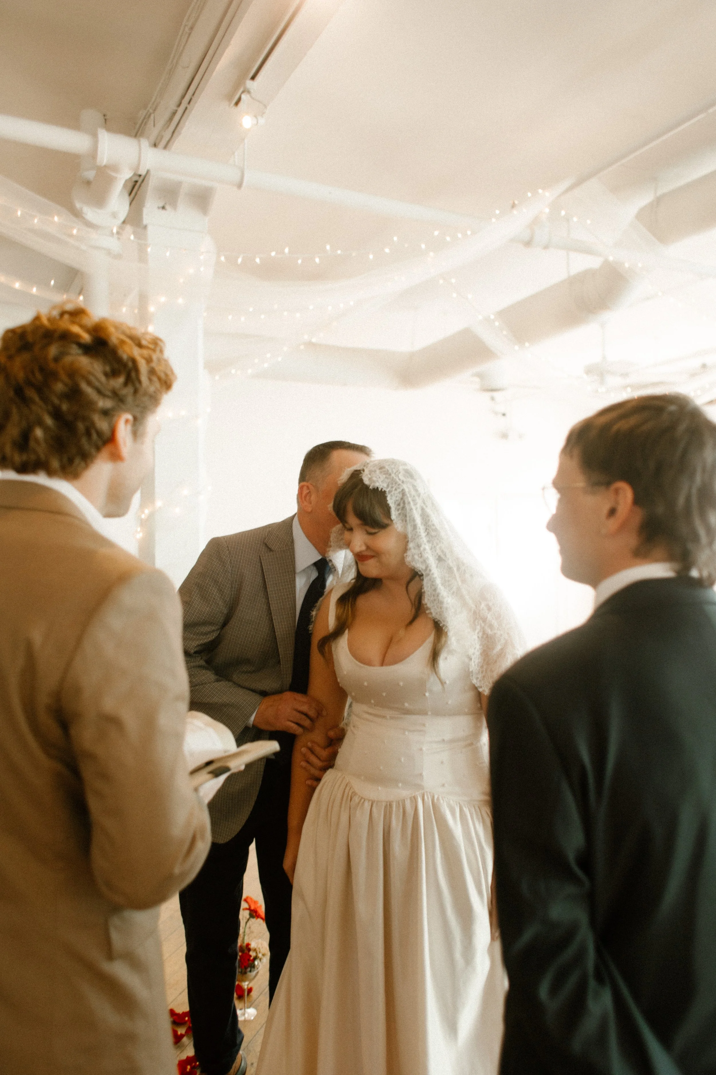 Bride walks down the aisle, guided by her dad and glowing with emotion