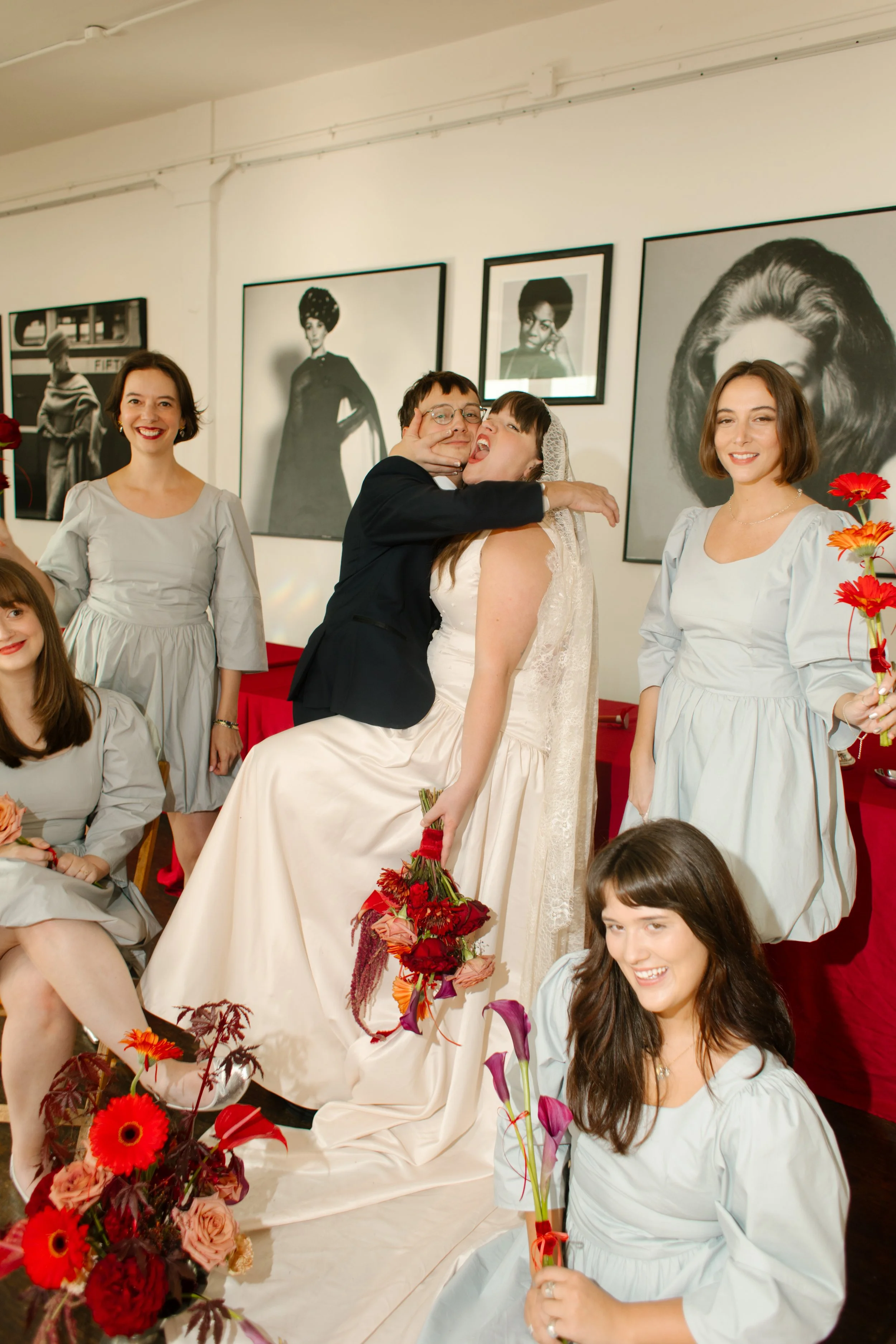 Bride and groom play silly together while bridal party laughs and celebrates