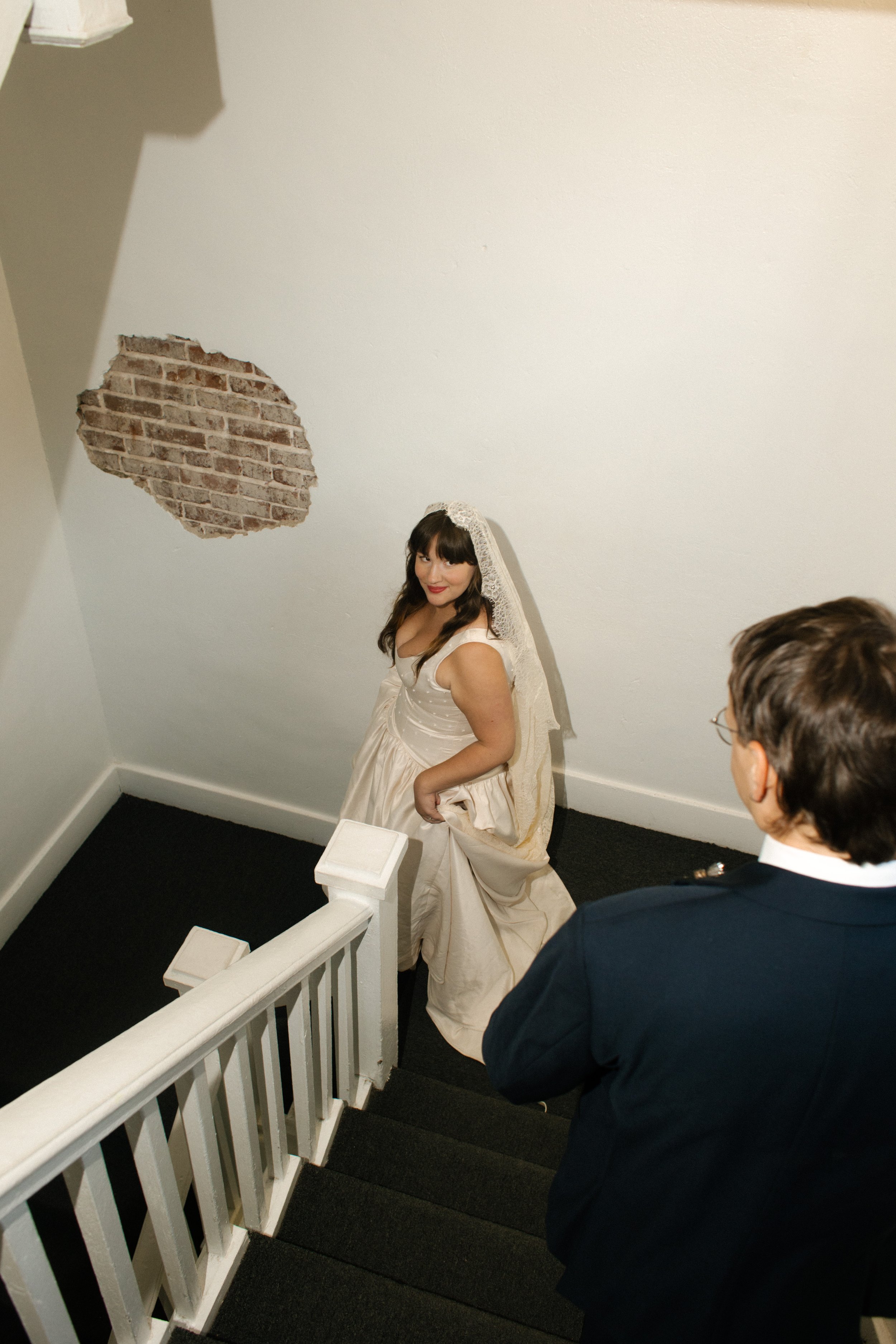 Bride and groom walk down staircase as newly married husband and wife after intimate Tennessee wedding