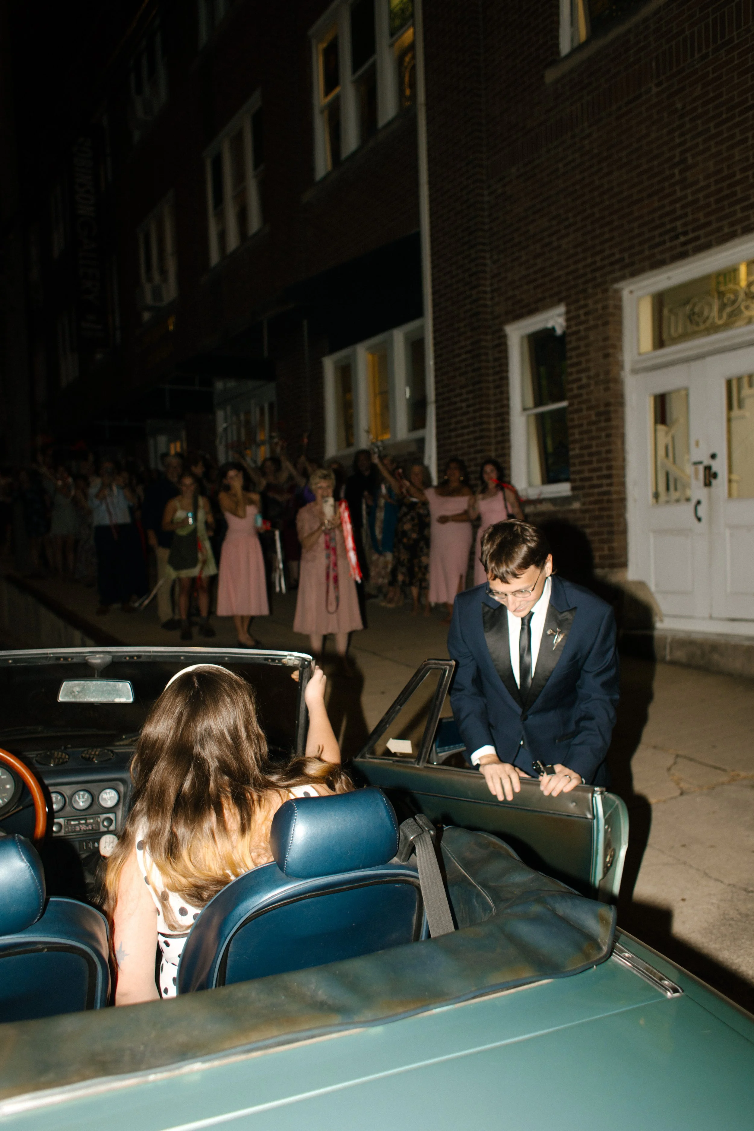 Groom let's his bride in their getaway vintage BMW after Tennessee wedding