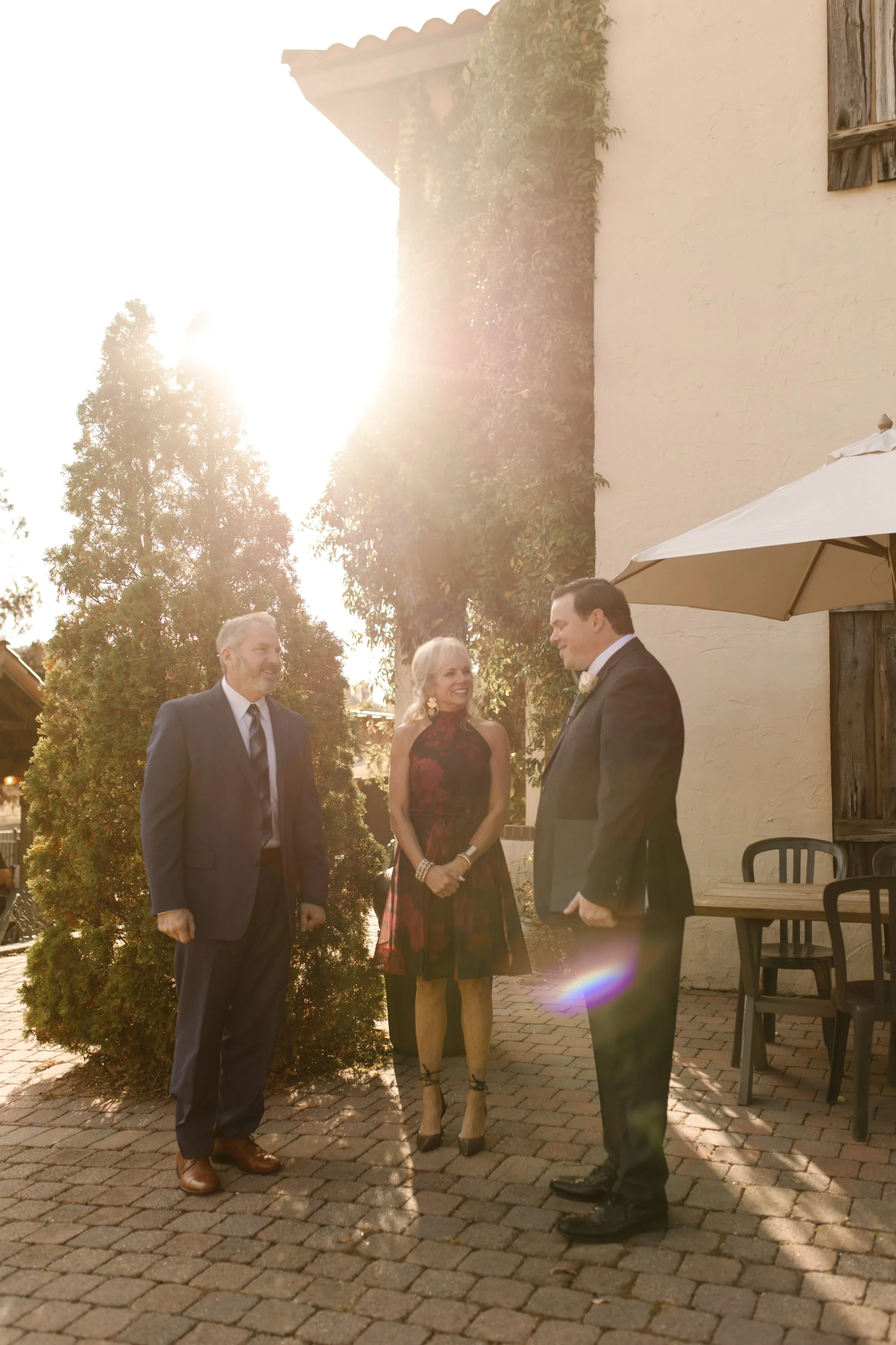 Family members sharing a candid moment in golden sunlight outside the villa