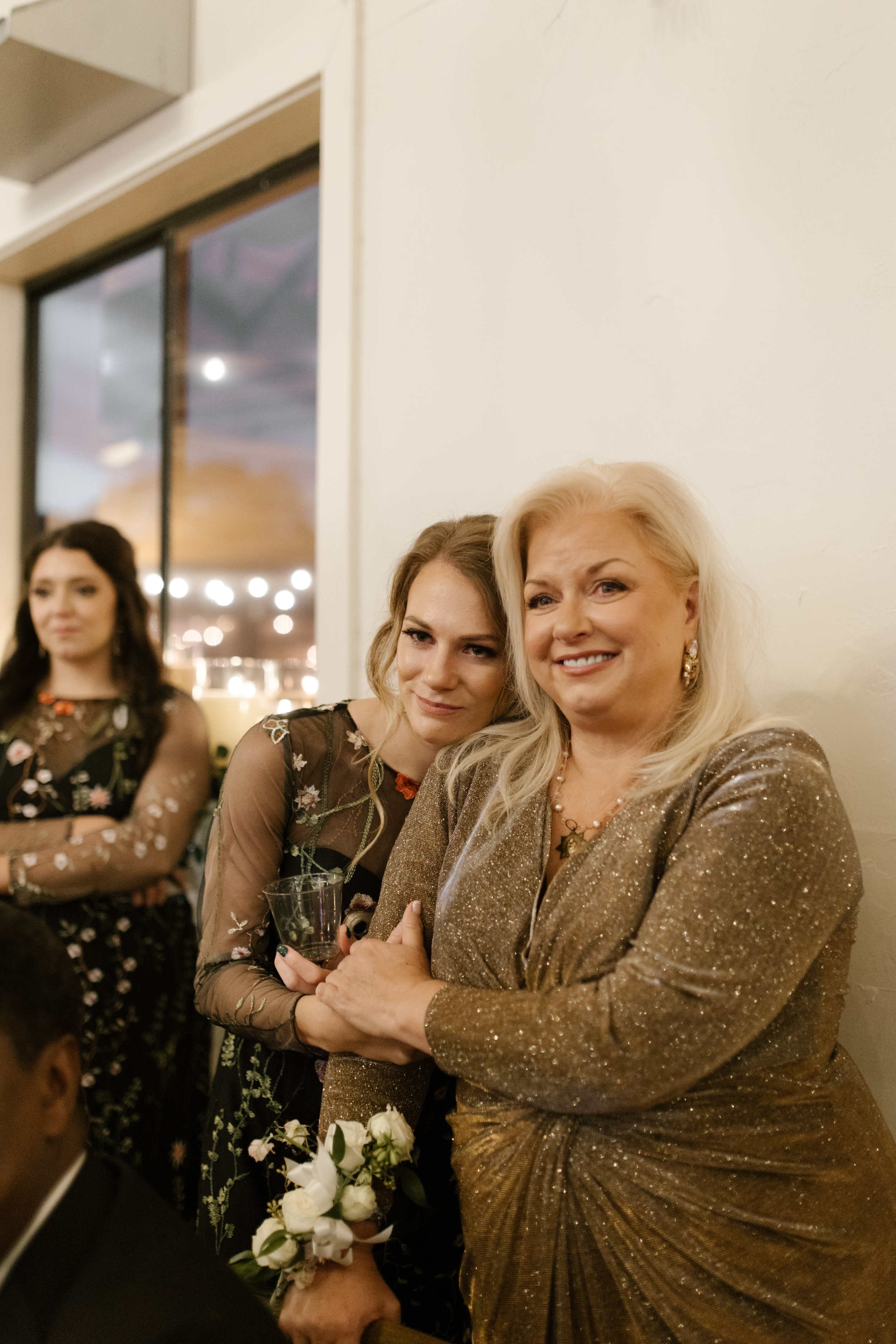 Mother of the bride embracing a bridesmaid during an emotional reception moment at an italy inspired wedding celebration.