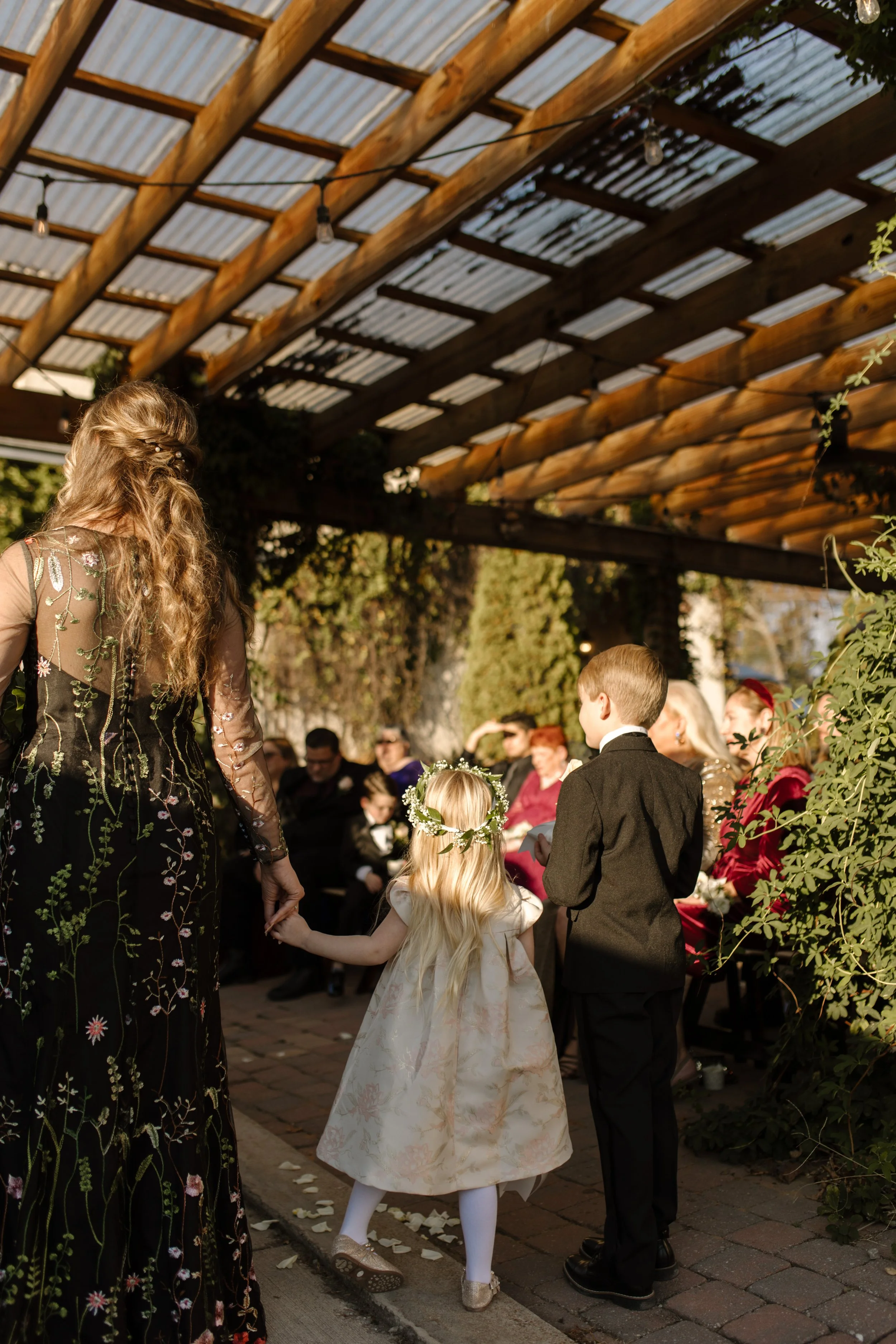 Flower girl and ring bearer walking hand in hand down the aisle