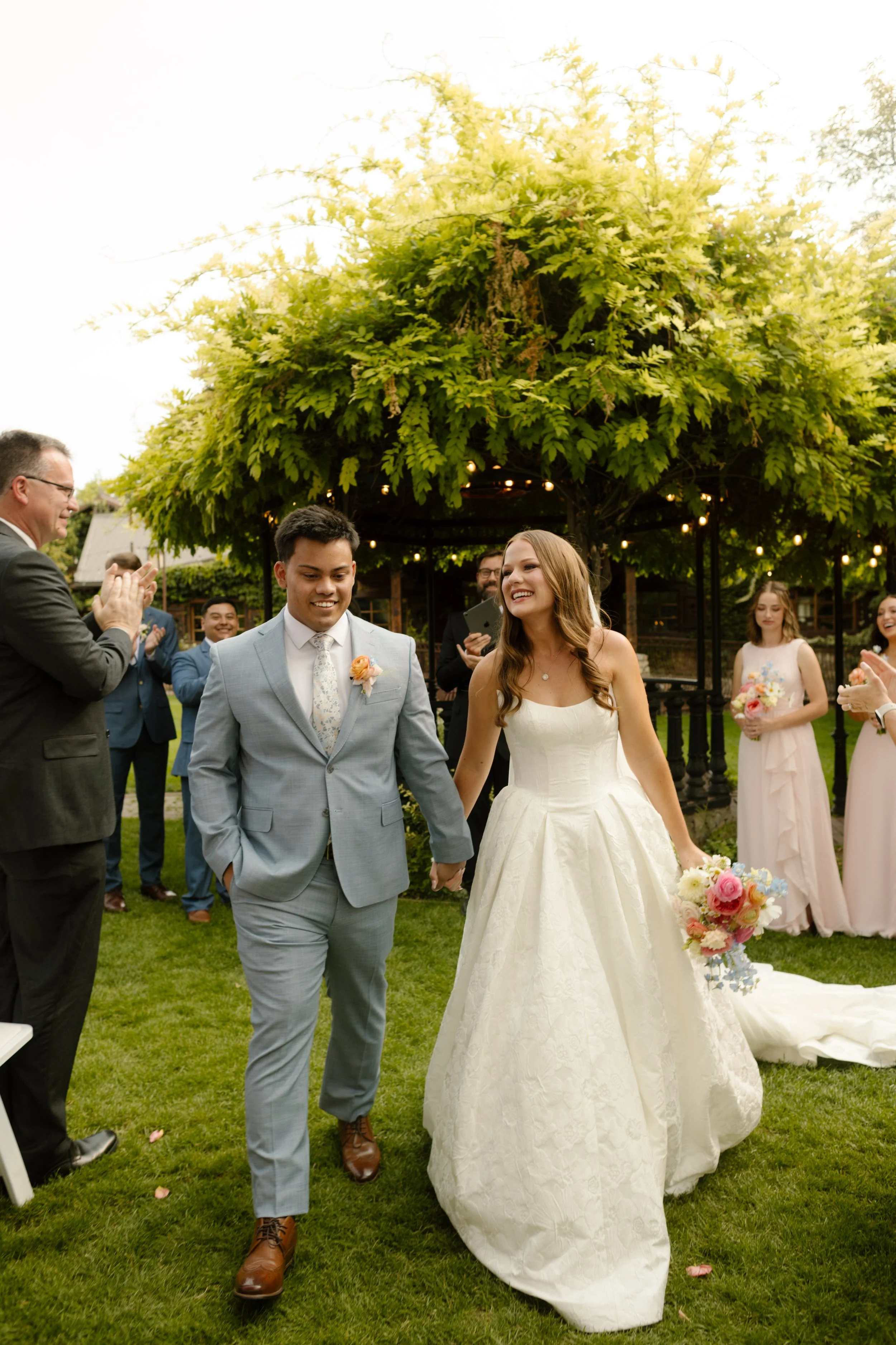 Newly married couple exiting wedding ceremony with all smiles. 