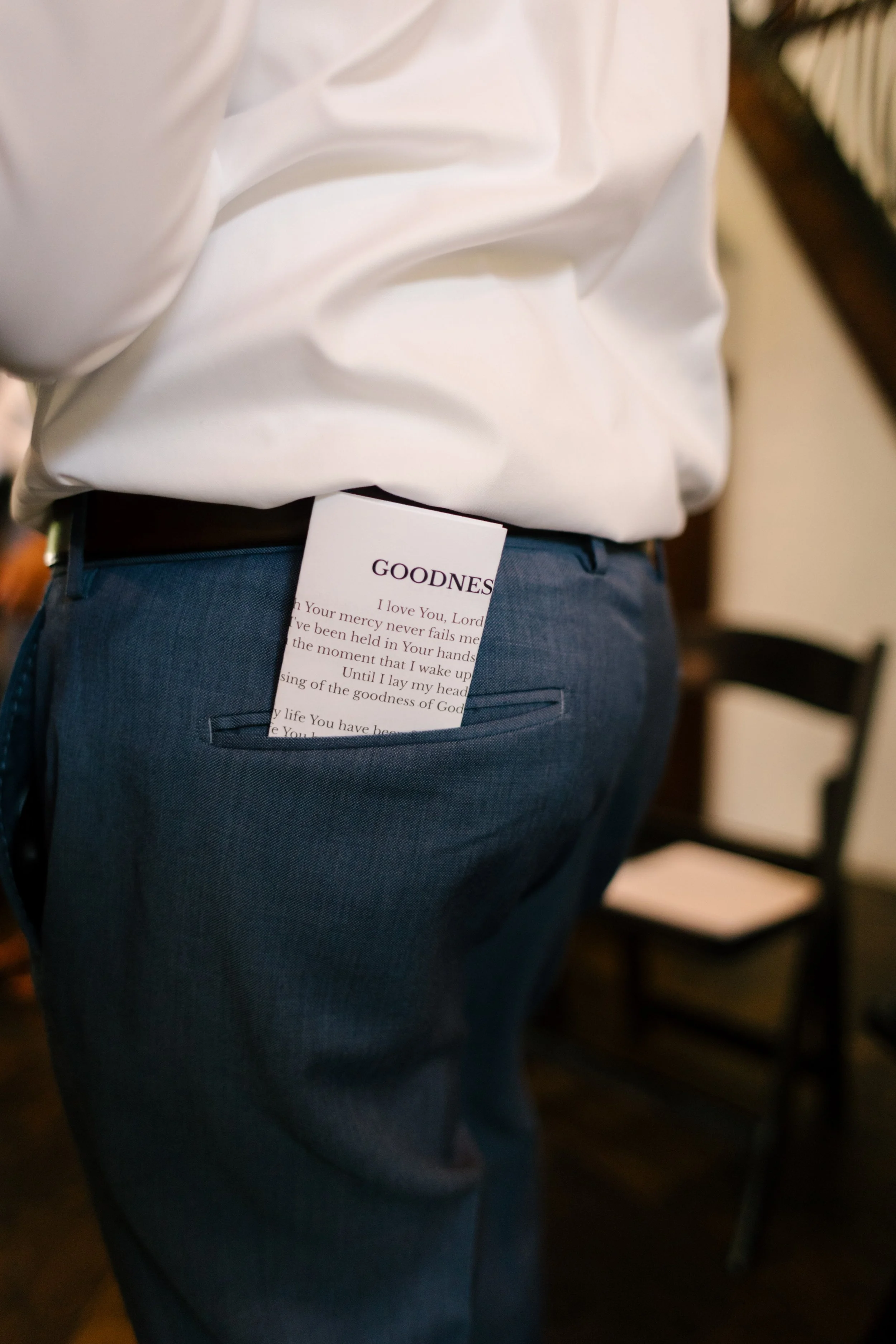 Back of groom with vows in his back pocket at utah wedding venue. 
