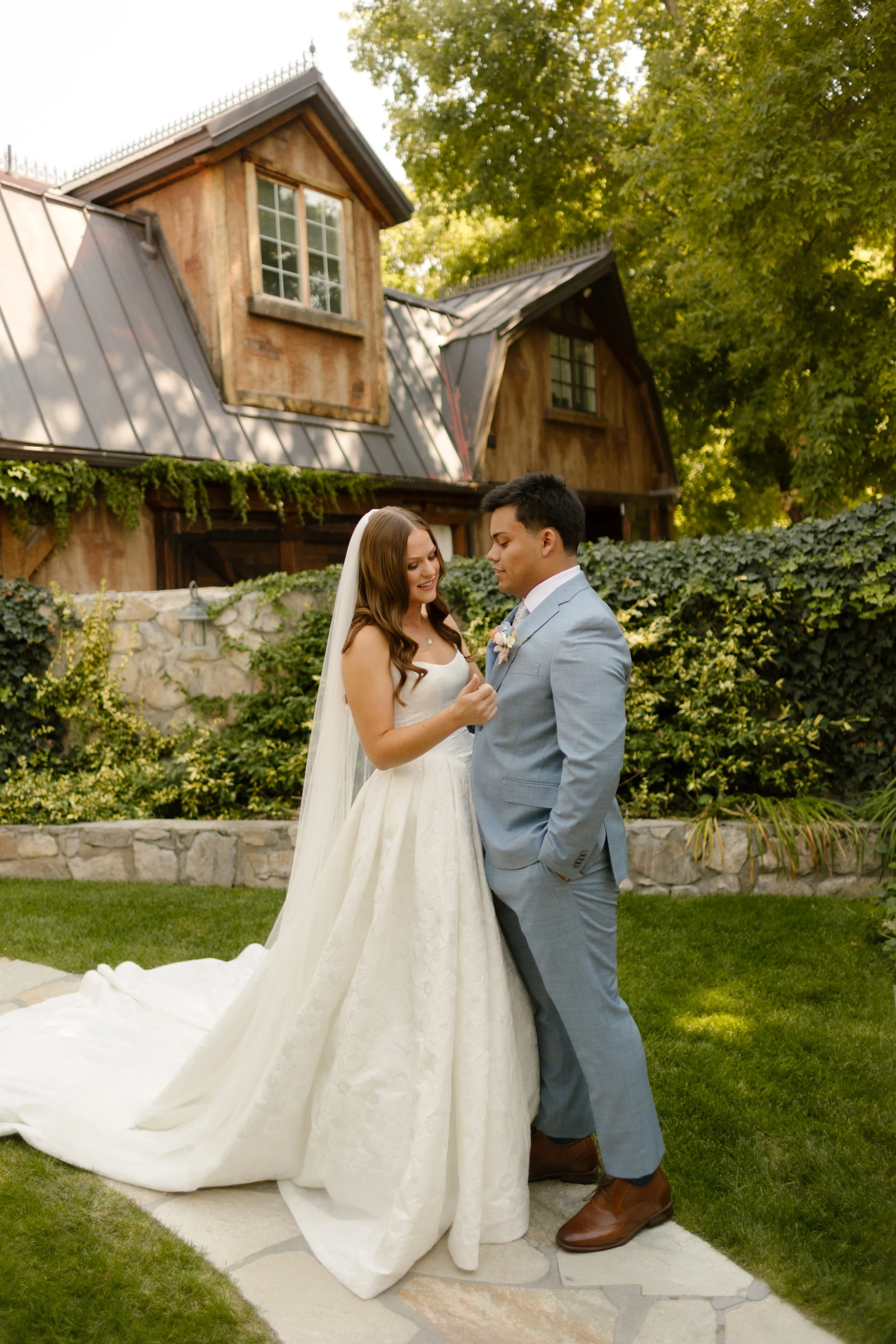 Bride and groom embrace while walking on sidewalk throughout utah wedding venue. 
