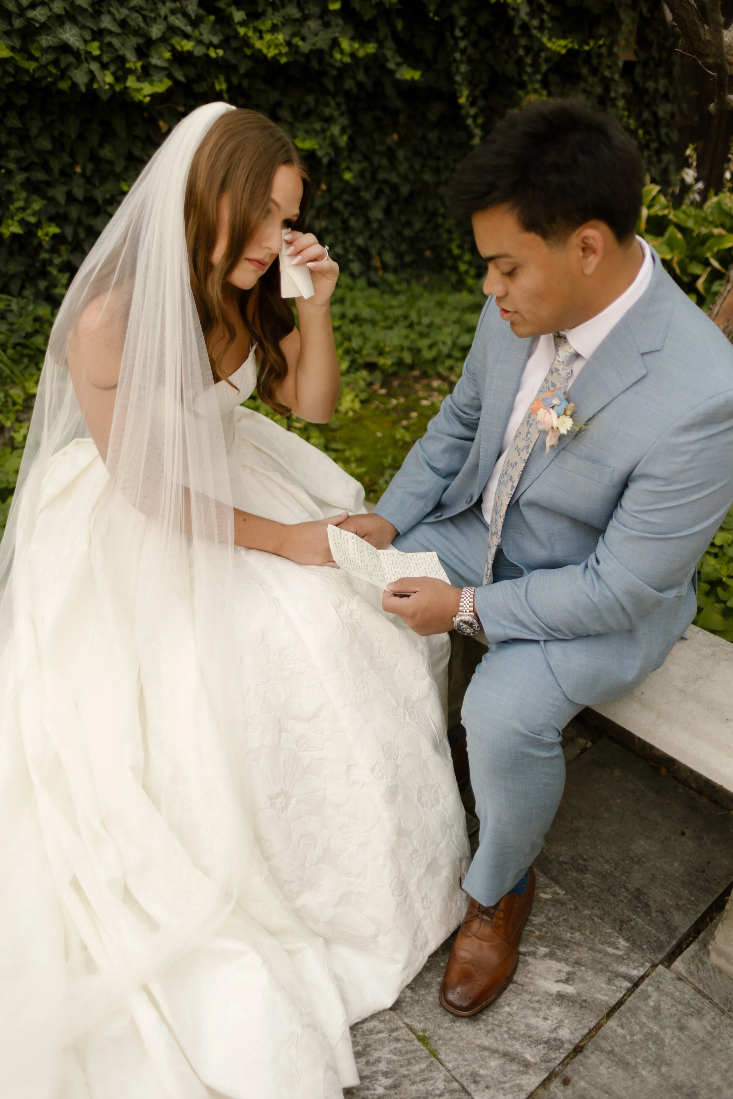 Bride wiping tears as her groom reads his vows to her in a private moment before their intimate wedding. 