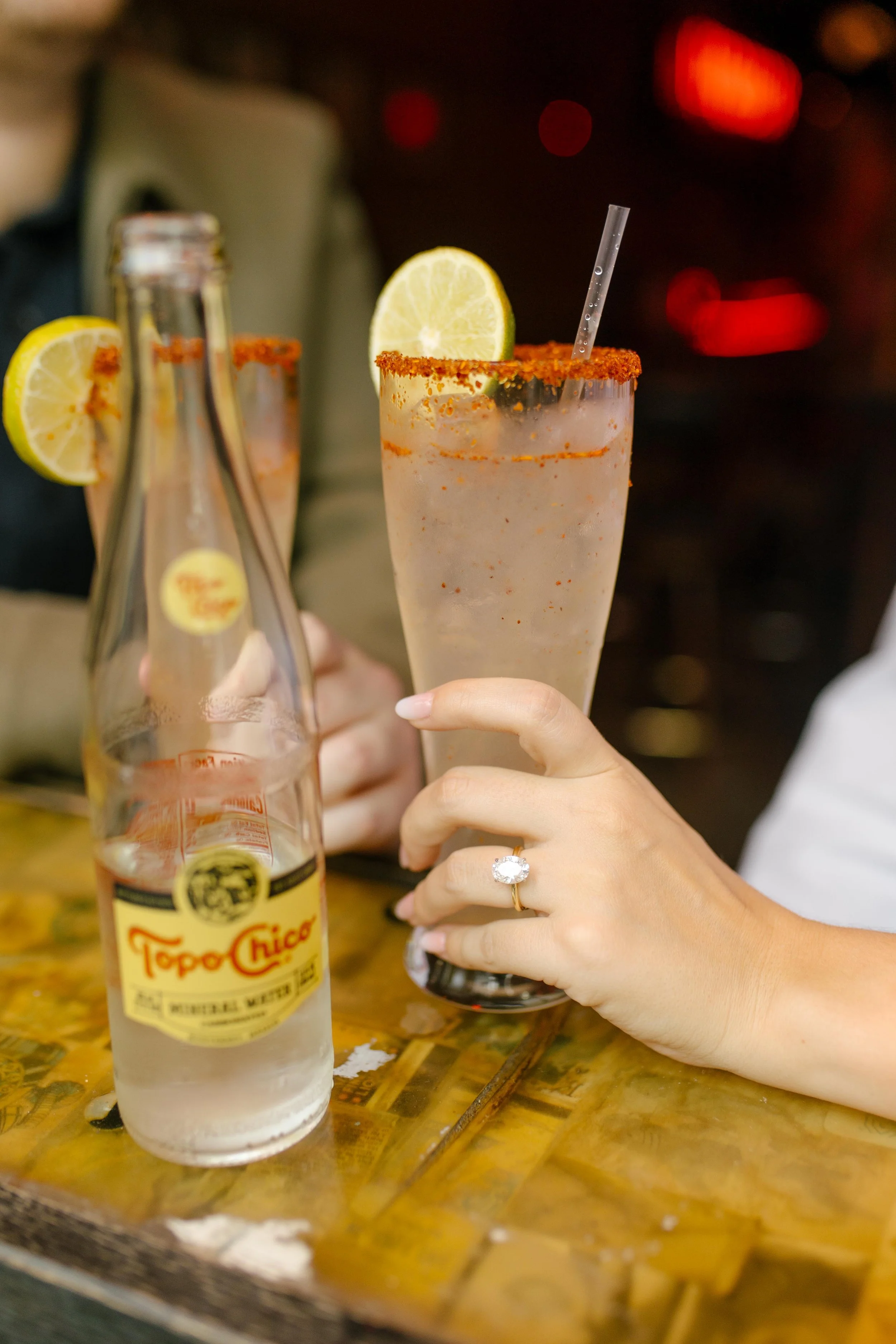 Close-up from nyc engagement photos showing engagement ring beside cocktails with chili-rimmed glasses.