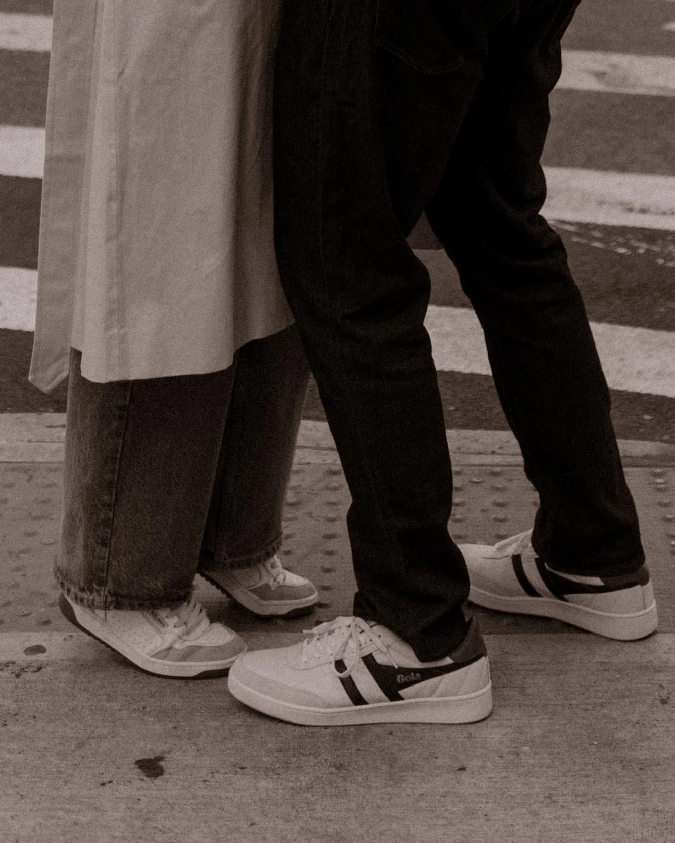 Moody detail shot of couple’s sneakers touching at a Brooklyn crosswalk during engagement session.