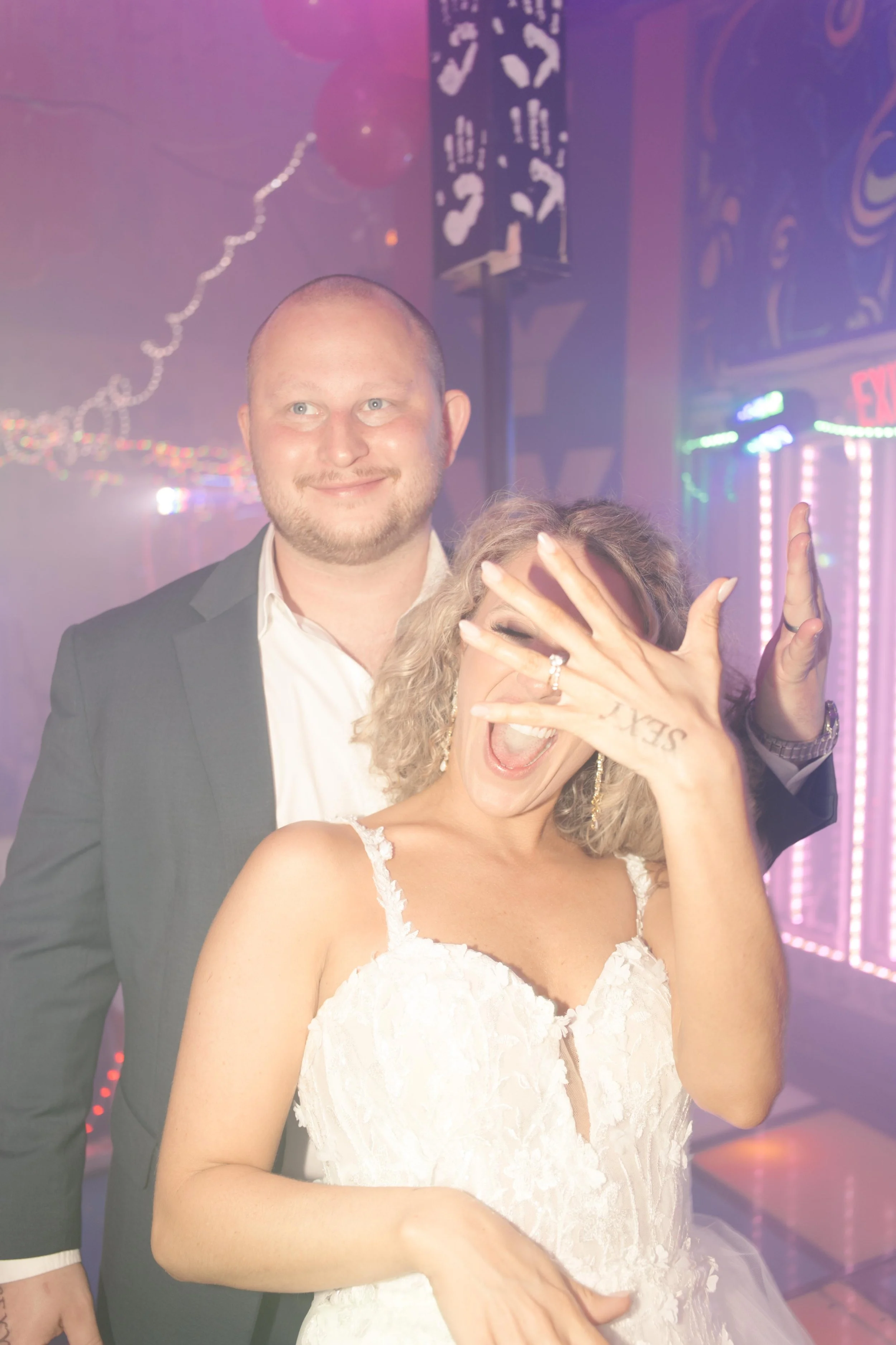 Bride excitedly showing her wedding ring on the dance floor during wedding after parties.