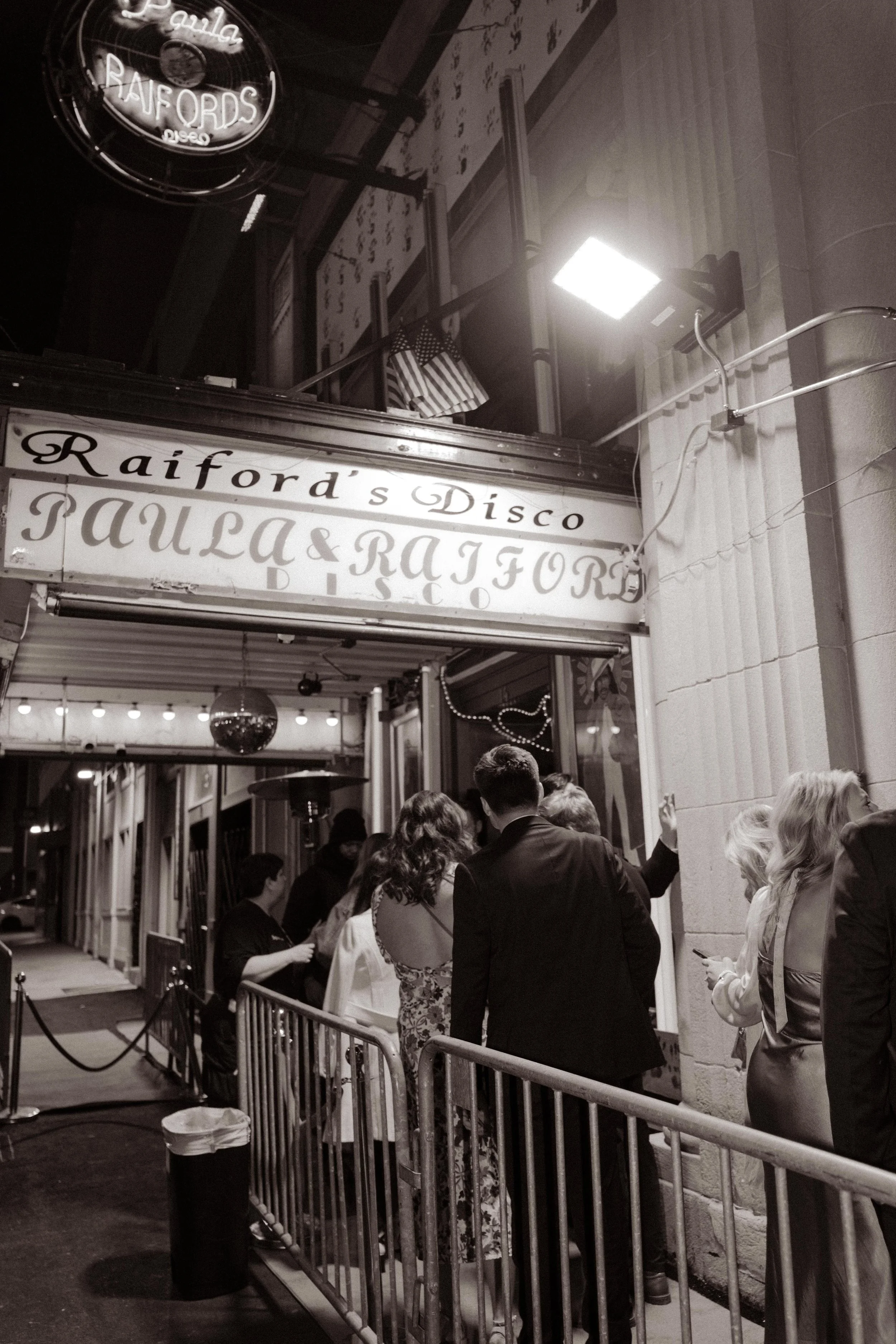 Guests lined up outside a nightclub entrance before heading inside for wedding after parties.