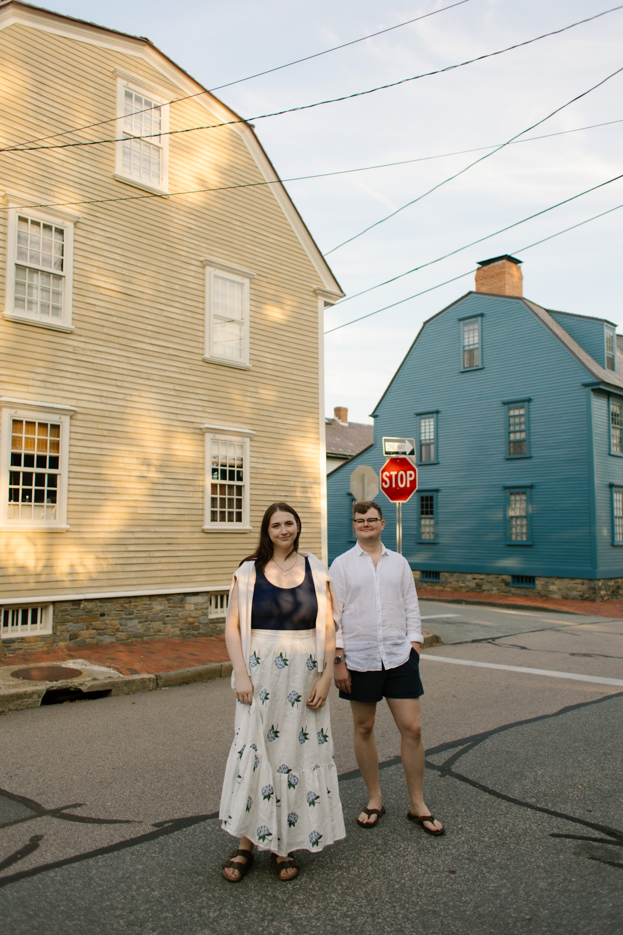 Couple standing on quiet Newport street between historic colonial homes