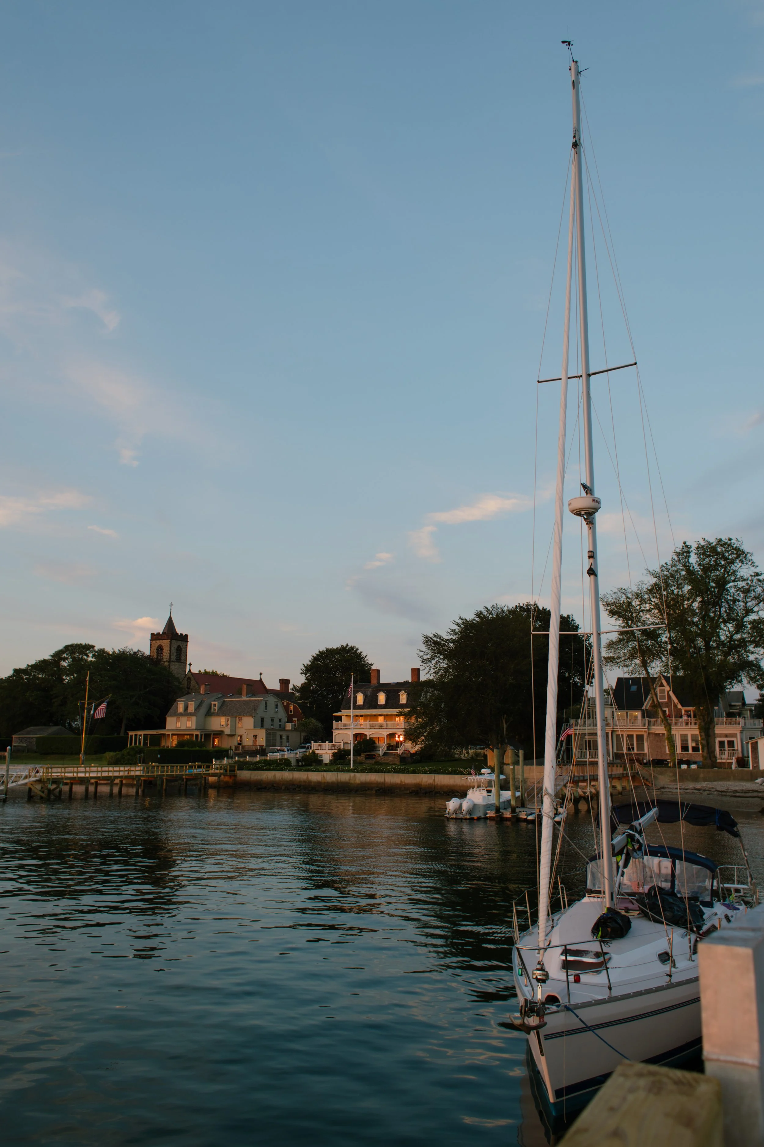 Sailboat docked along Newport harbor at blue hour