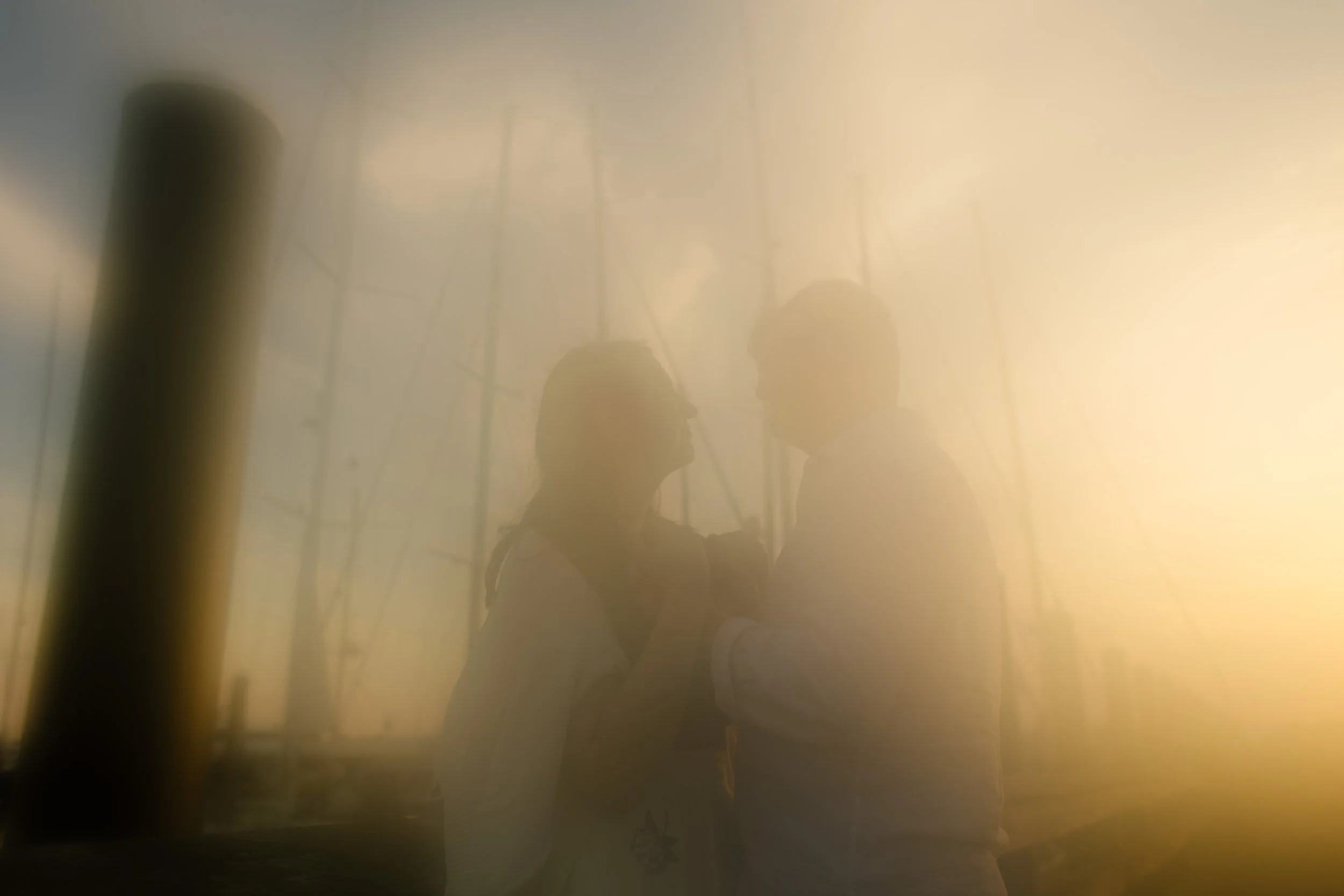 Dreamy silhouette of couple embracing on dock at sunset during Newport Rhode Island engagement photos