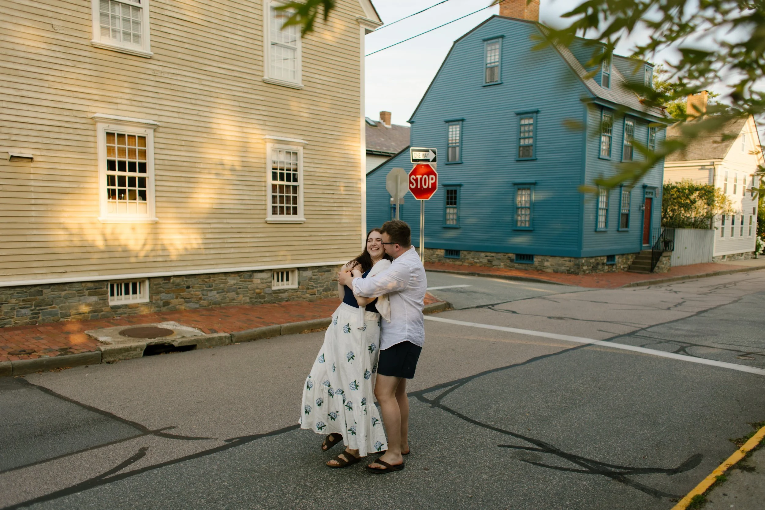 Playful moment of couple hugging in historic Newport Rhode Island street