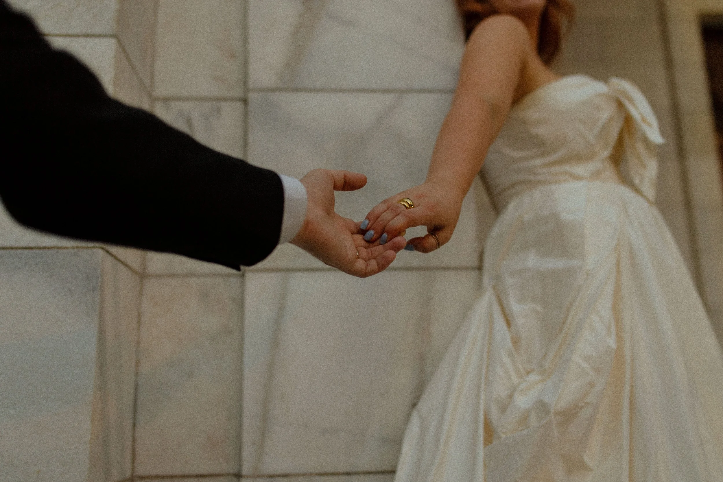 Close-up of hands reaching and intertwining, the bride leading slightly ahead in a romantic and storytelling-driven pre wedding photos moment.
