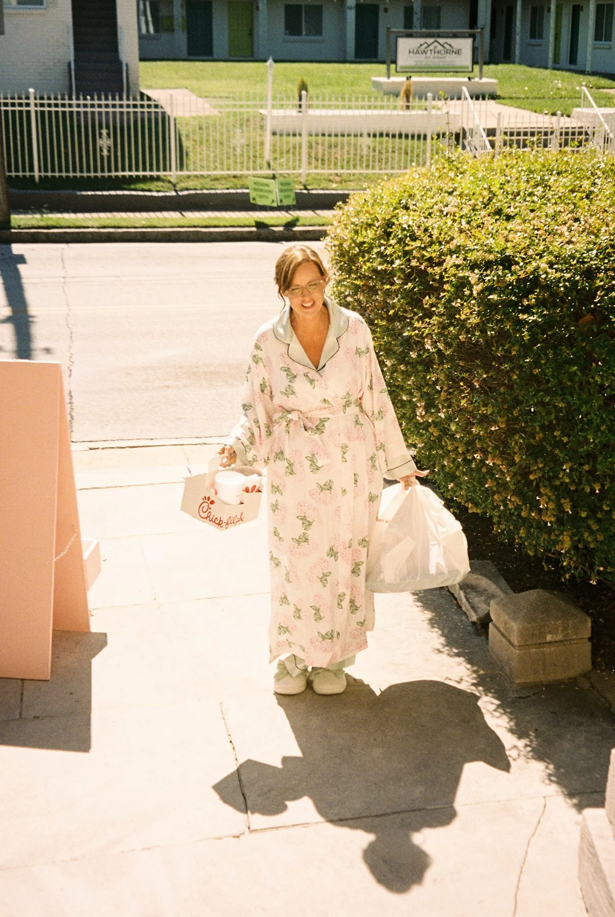 bride in floral robe arriving with chick-fil-a and bags in hand, candid getting ready moment before wedding day