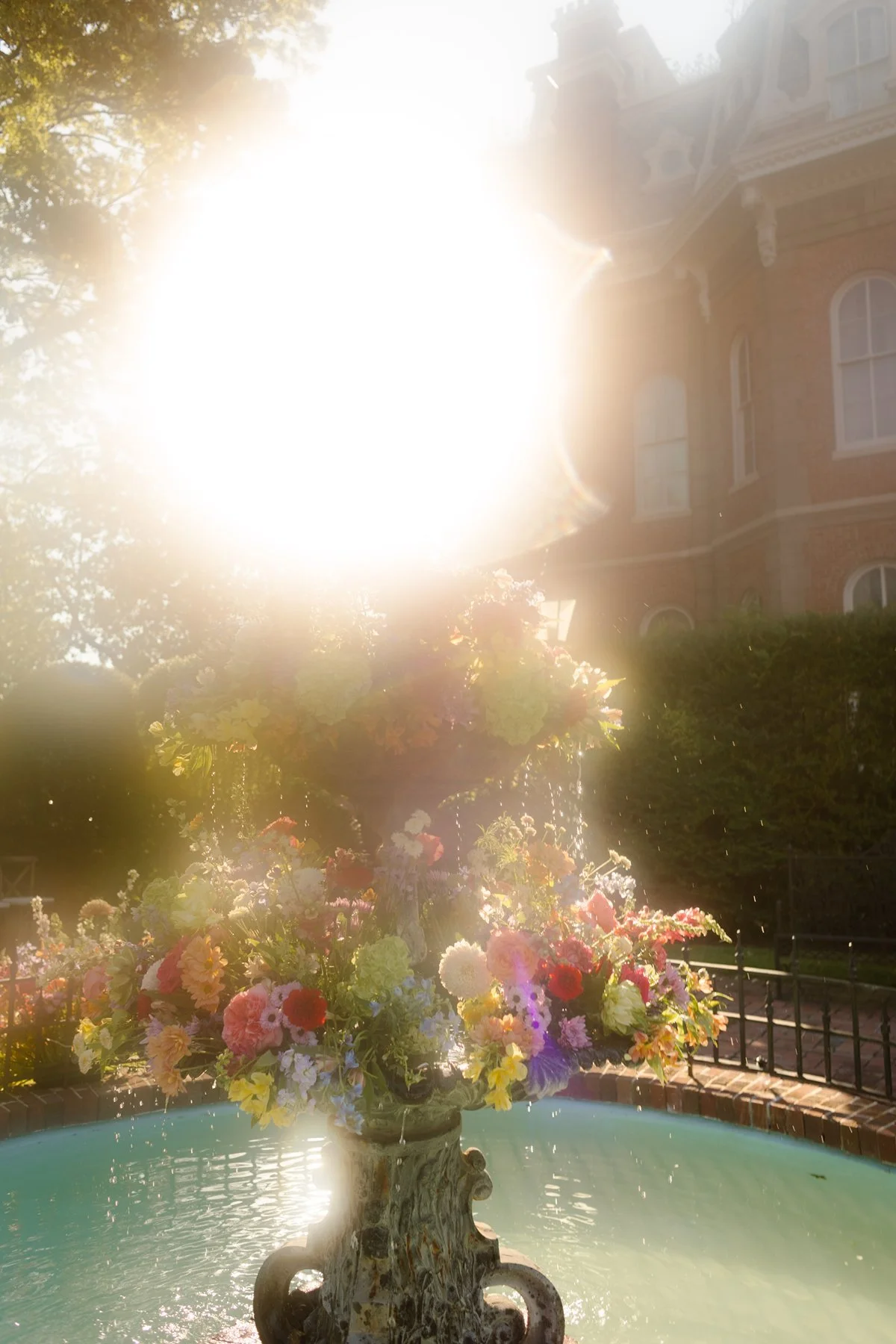 sunlight pouring over floral fountain centerpiece, dreamy haze and water droplets glowing at a memphis wedding venue