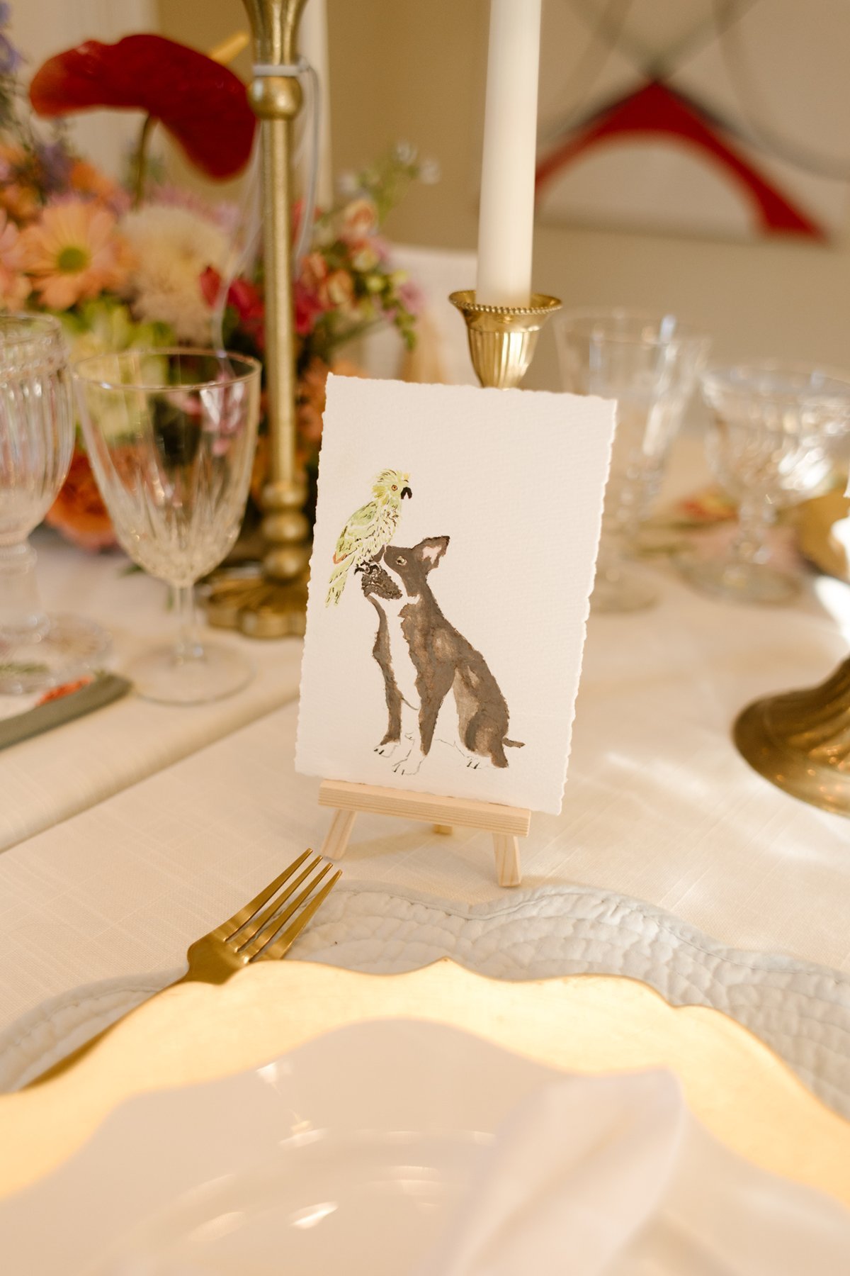 hand-painted place card featuring dog and bird illustration, personalized and artistic wedding reception detail