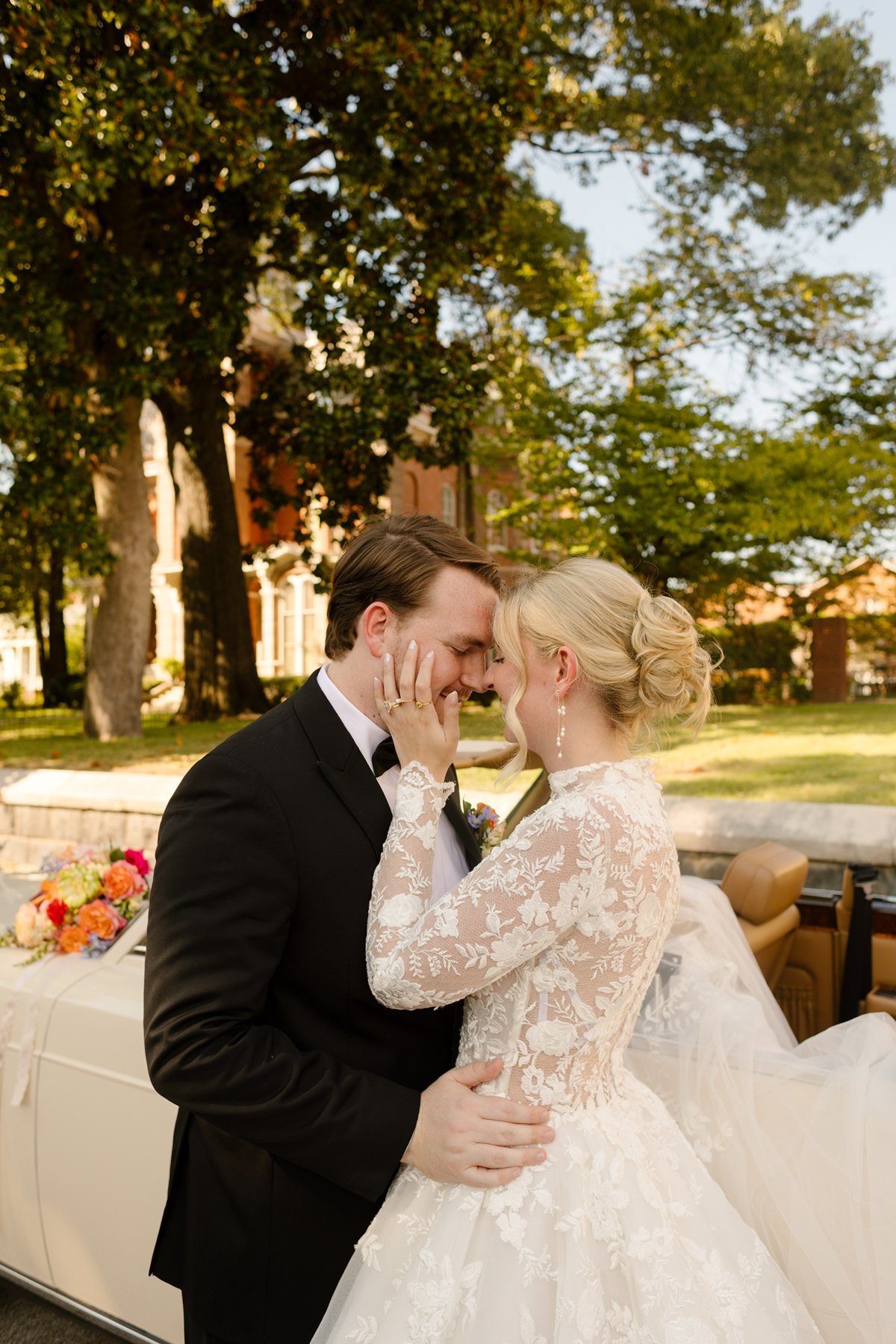 bride and groom sharing an intimate moment beside vintage convertible, soft afternoon light and romantic garden setting