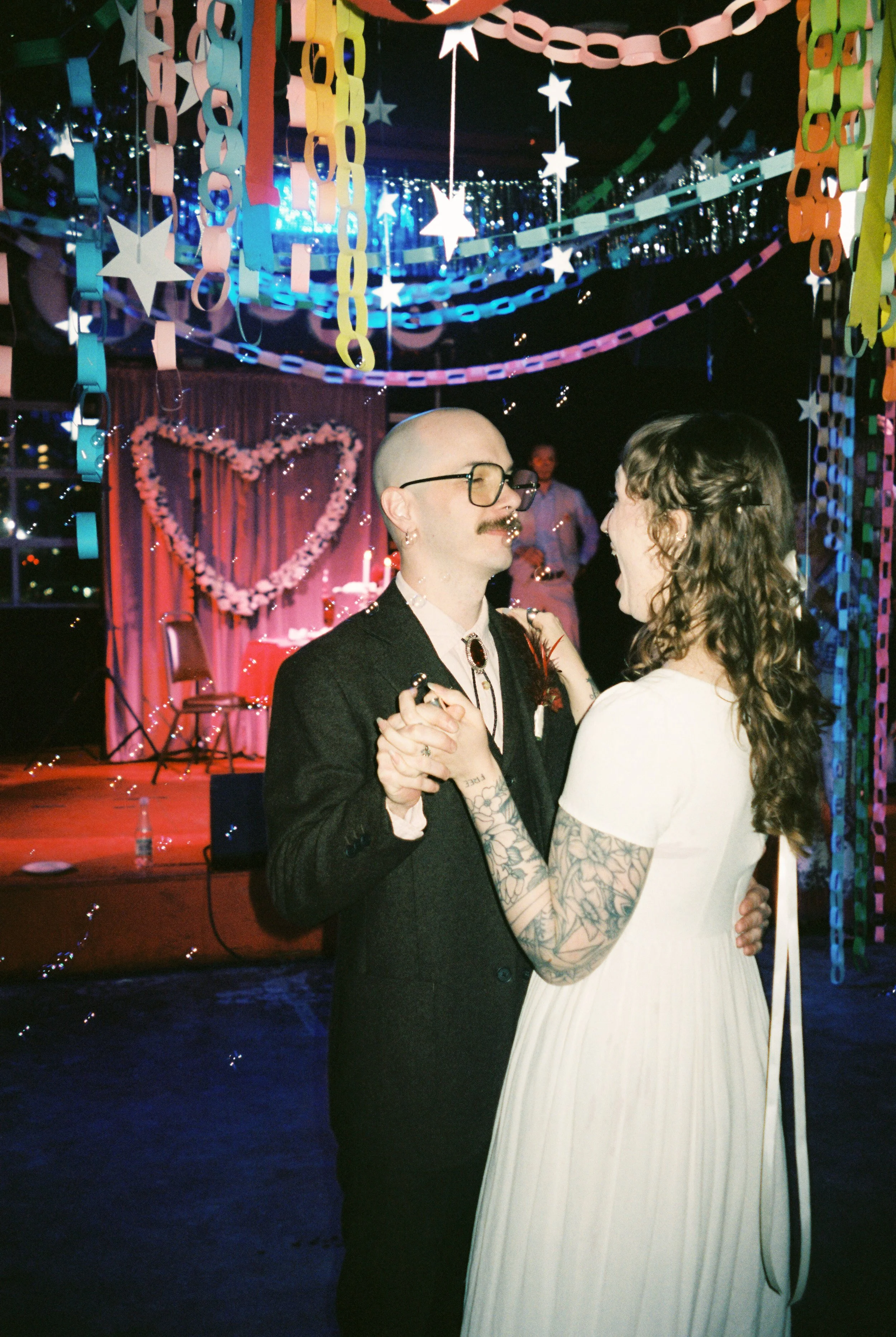 Couple dancing under colorful paper chains and star decorations at a Memphis wedding reception filled with playful, handmade details