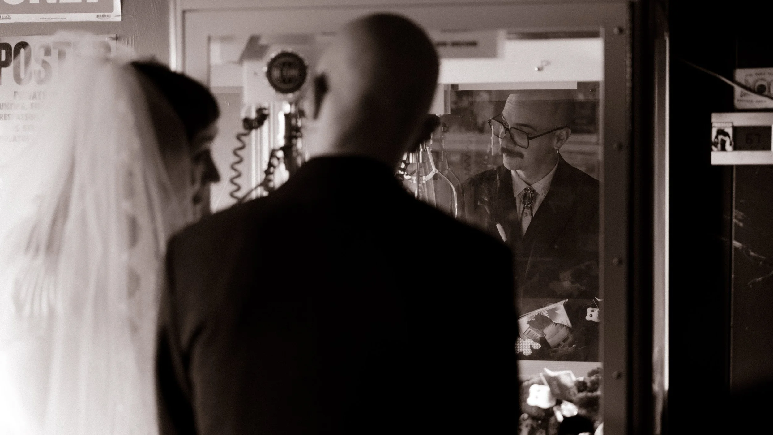 Groom reflected in a mirror while getting ready, creating a cinematic and artistic wedding portrait
