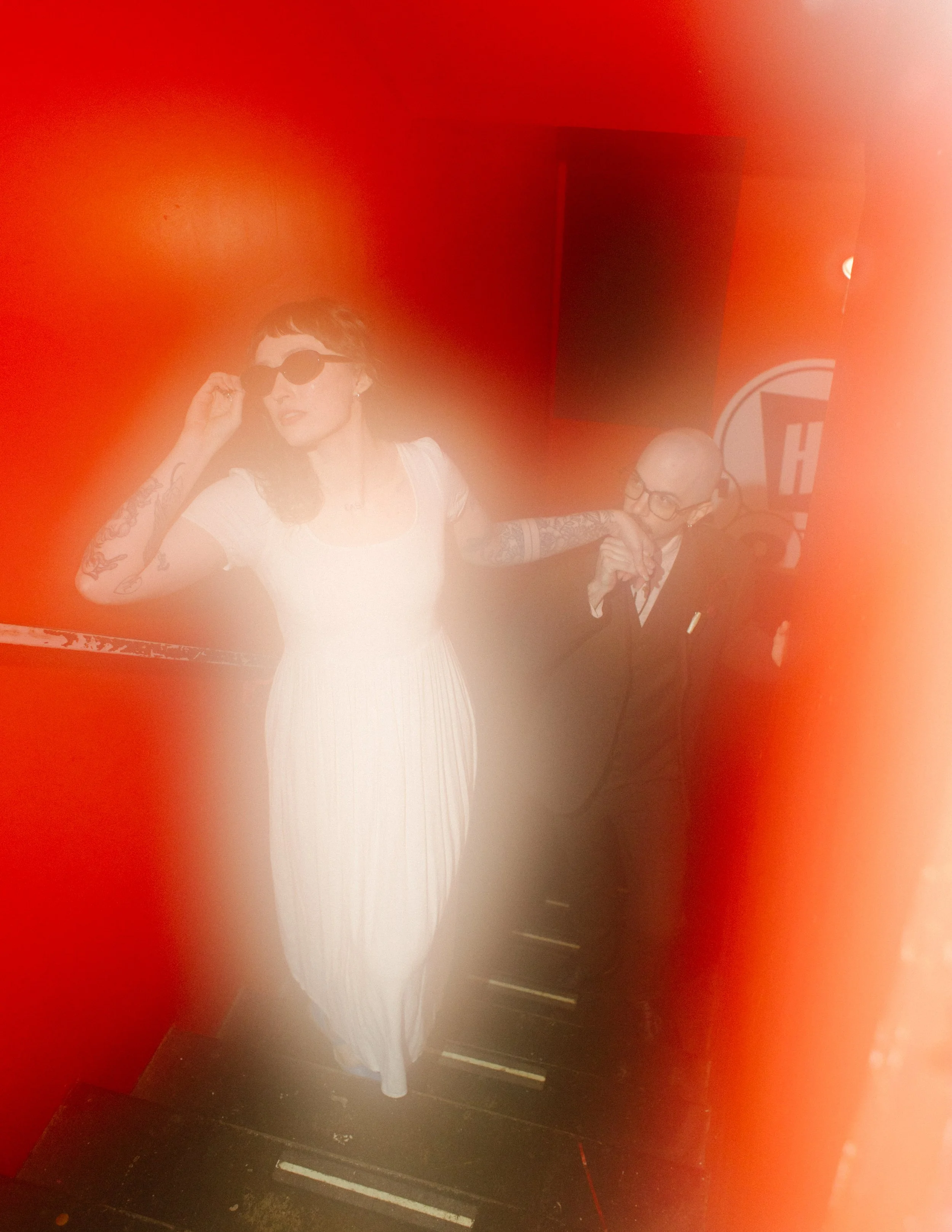 Bride wearing sunglasses while being playfully led by groom through venue, highlighting candid and personality-filled unique wedding ideas