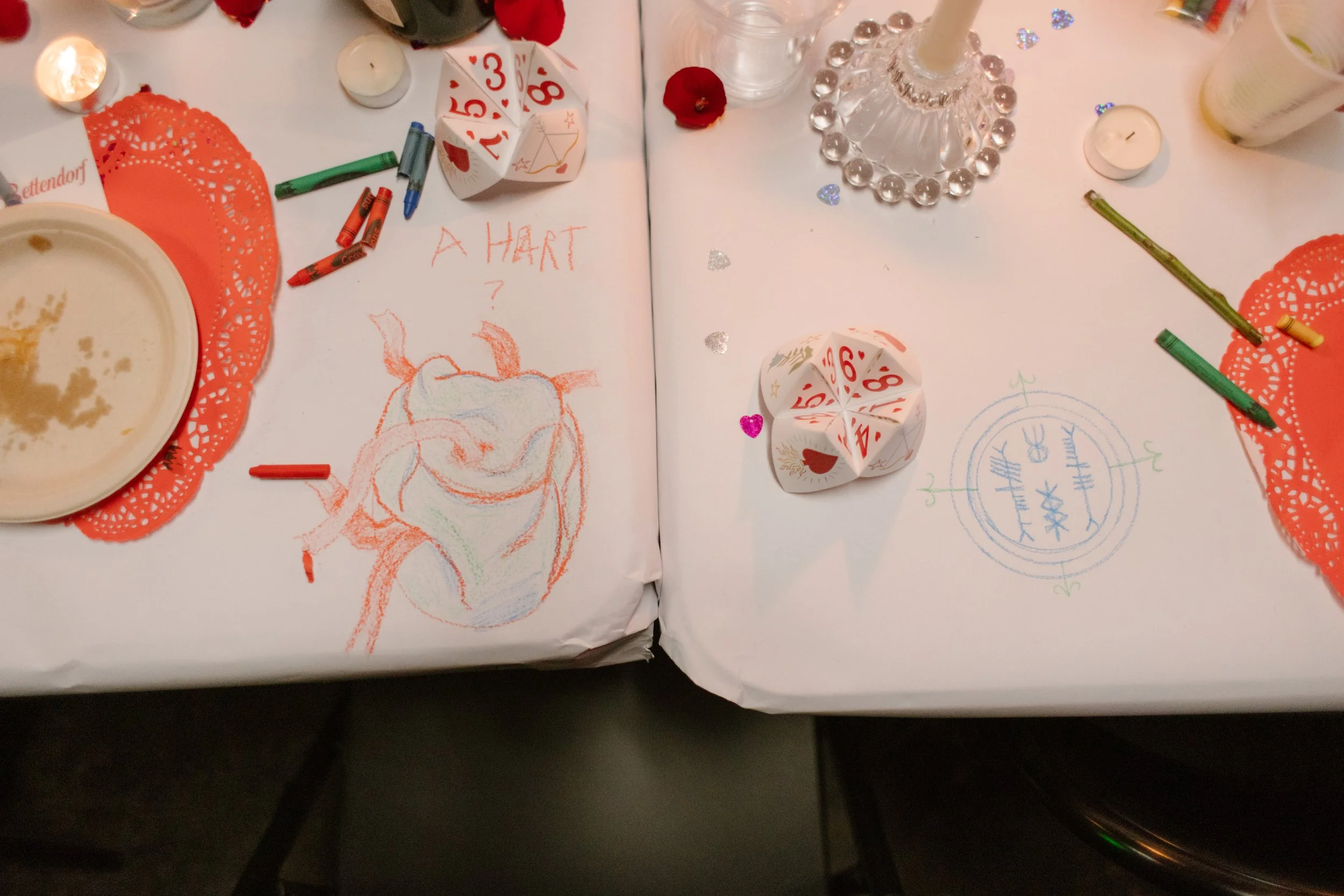 Reception tables with crayon drawings, candles, and playful sketches, highlighting interactive and creative unique wedding ideas