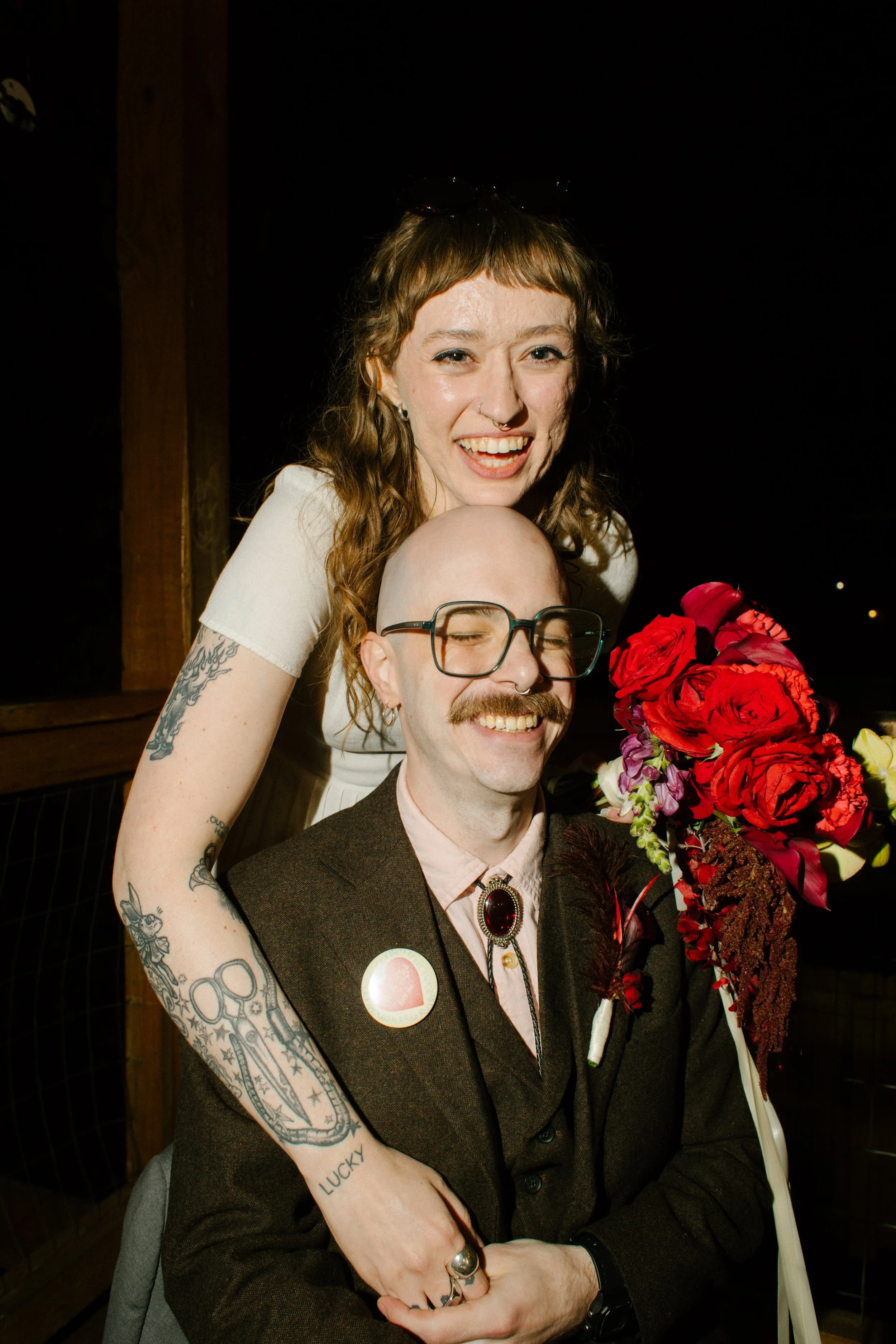 Bride hugging groom from behind while holding bouquet, capturing playful and intimate unique wedding ideas