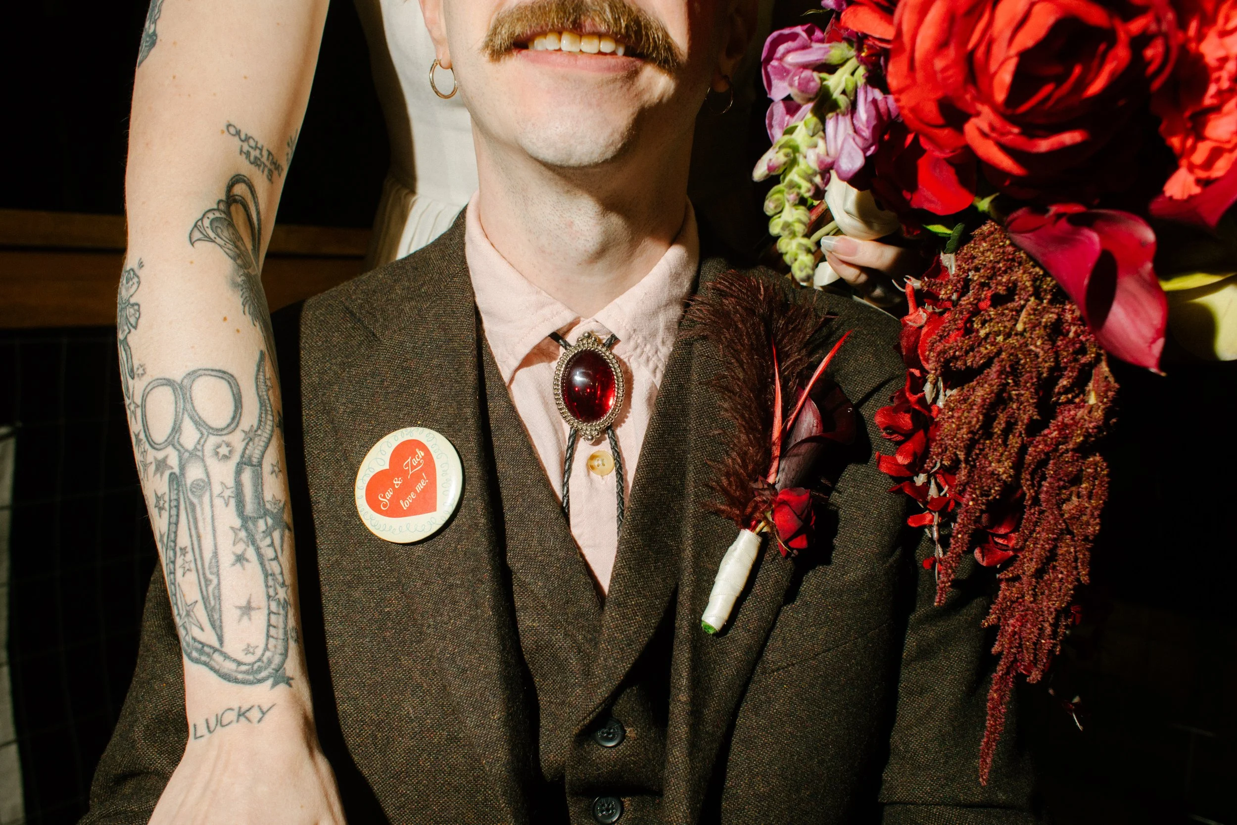 Close-up of groom’s bolo tie, boutonniere, and wedding details, highlighting stylish and alternative unique wedding ideas