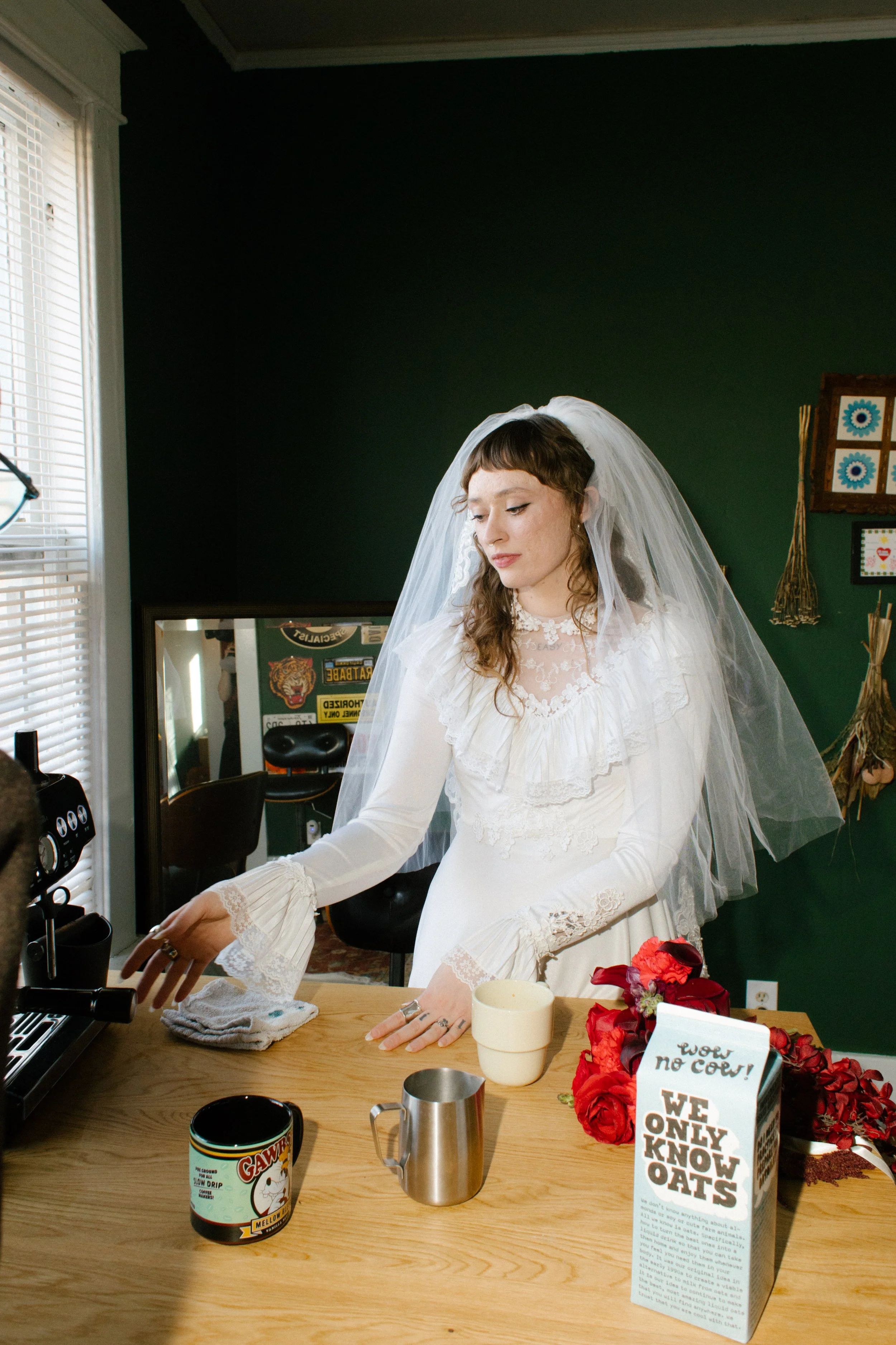 Bride making coffee in wedding dress with bouquet nearby, showcasing playful and everyday-inspired unique wedding ideas