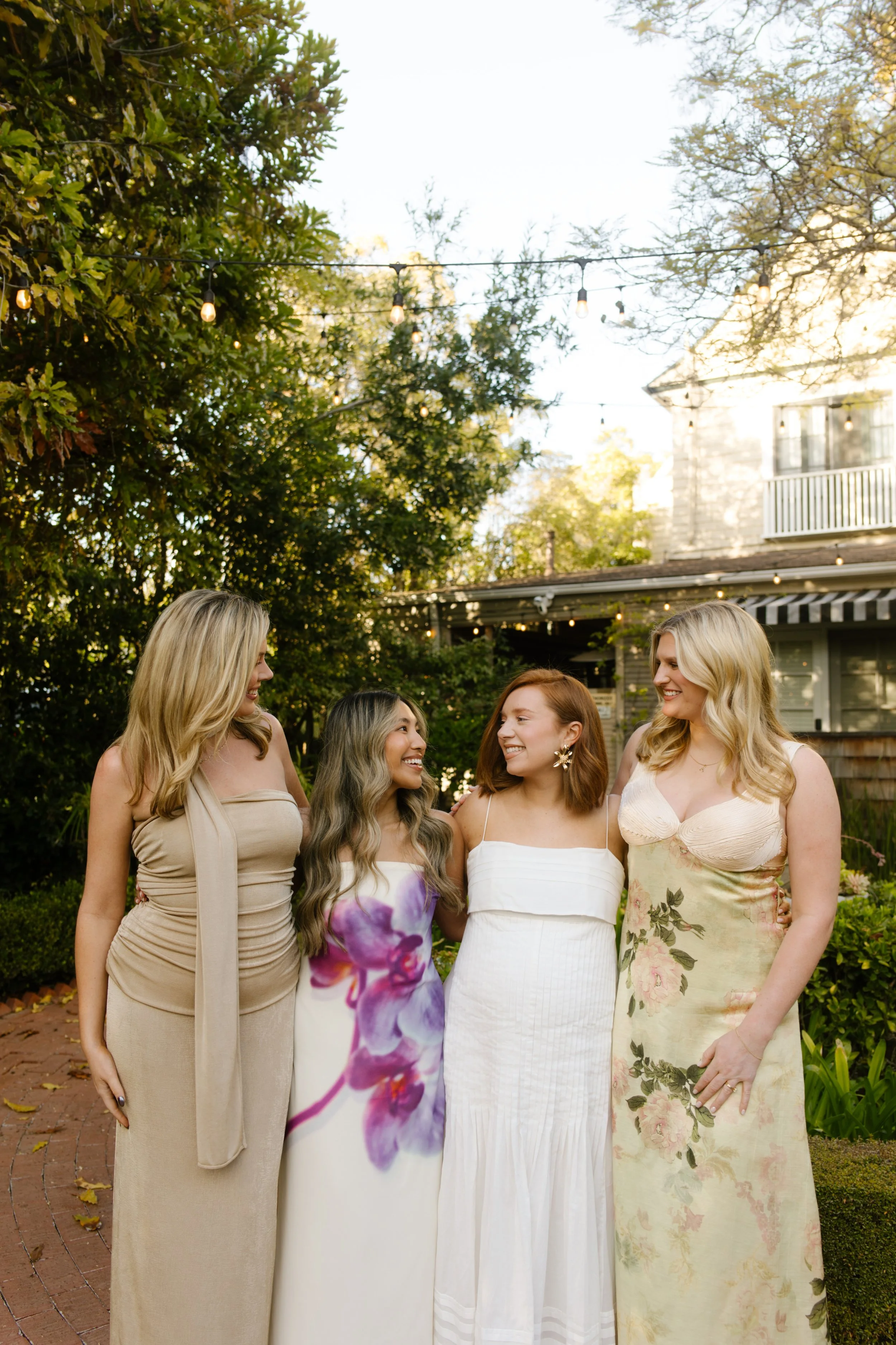 Bridesmaids standing together in a garden, smiling and embracing during a wedding weekend in Santa Barbara