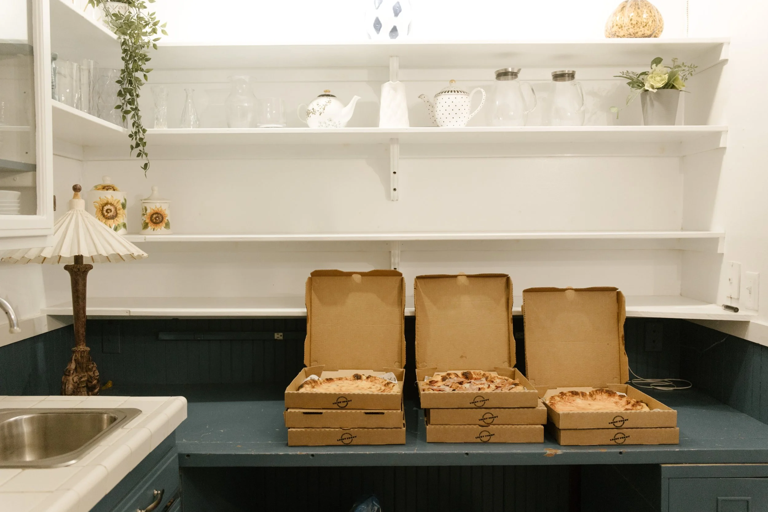 Pizza boxes lined up in a bright kitchen during a relaxed wedding weekend in Santa Barbara