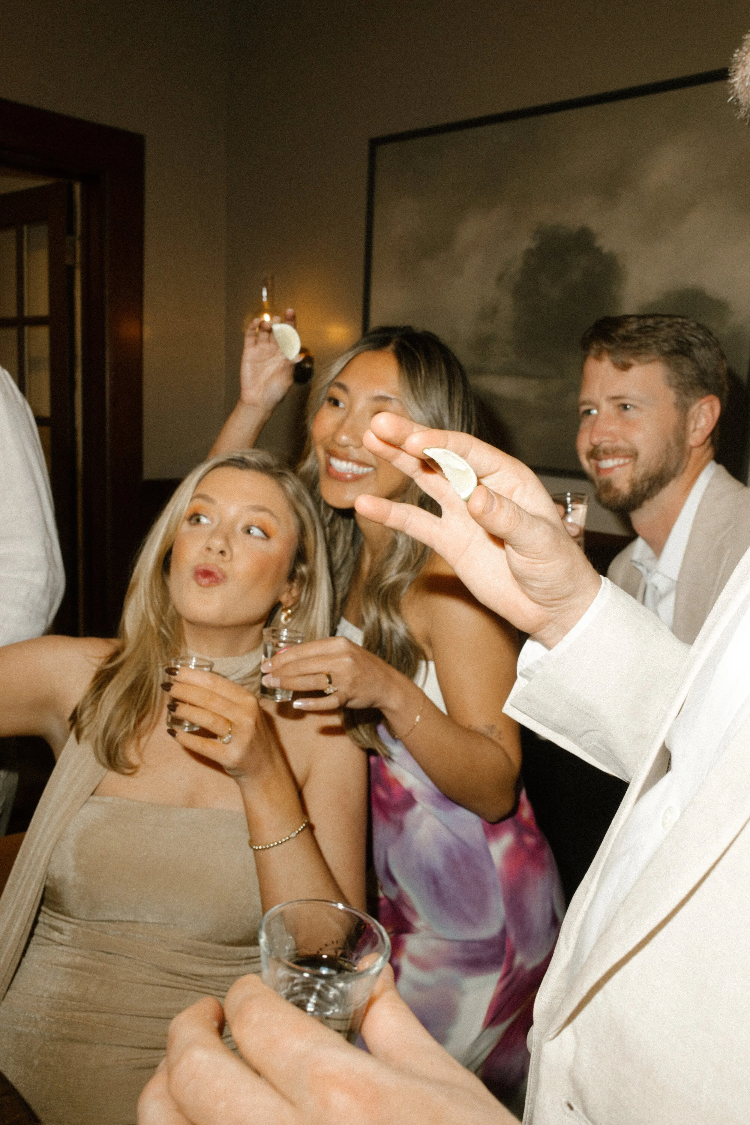 Group of guests posing with drinks and lime wedges during a fun wedding celebration