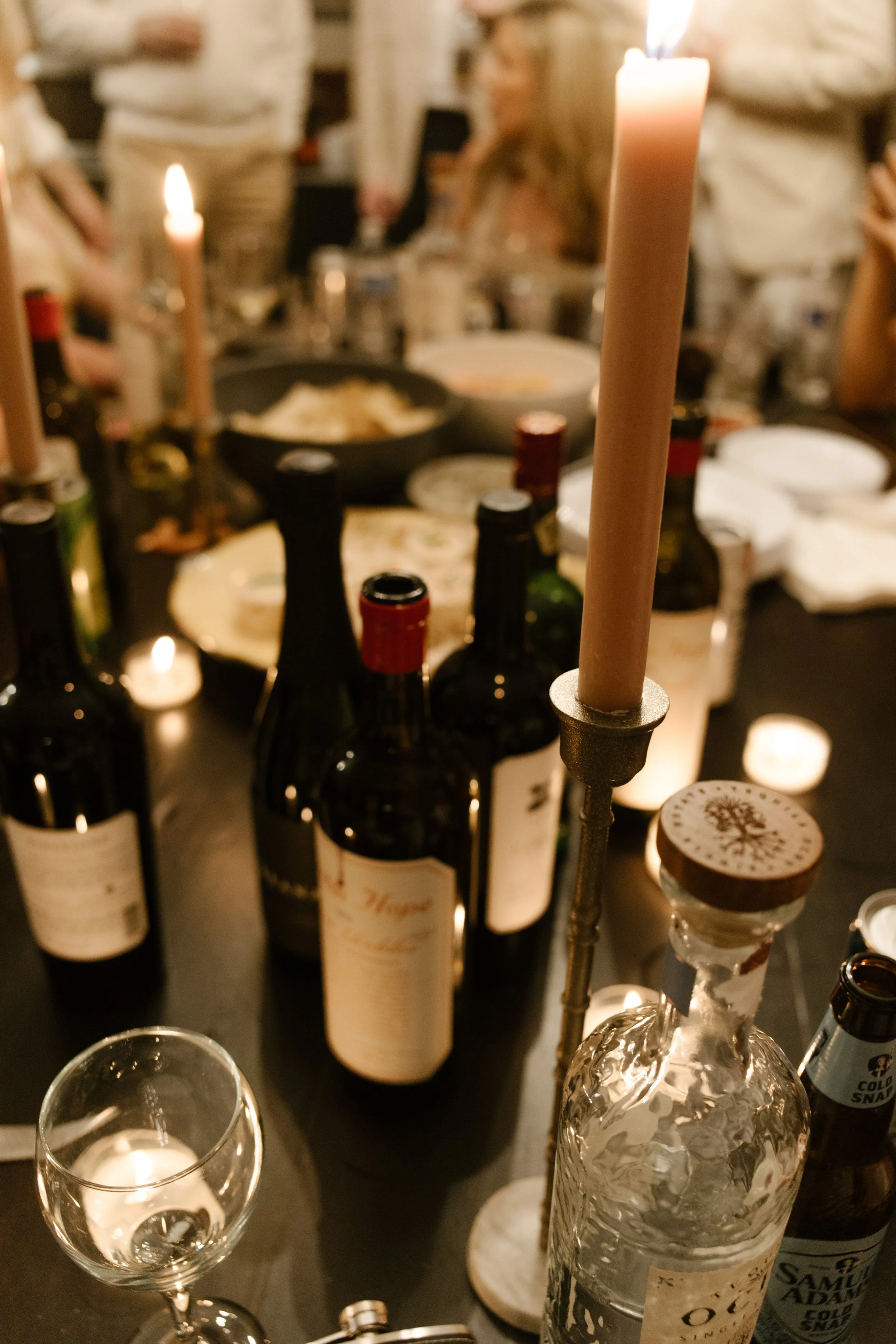 Close-up of wine bottles, candles, and table details during an intimate wedding dinner