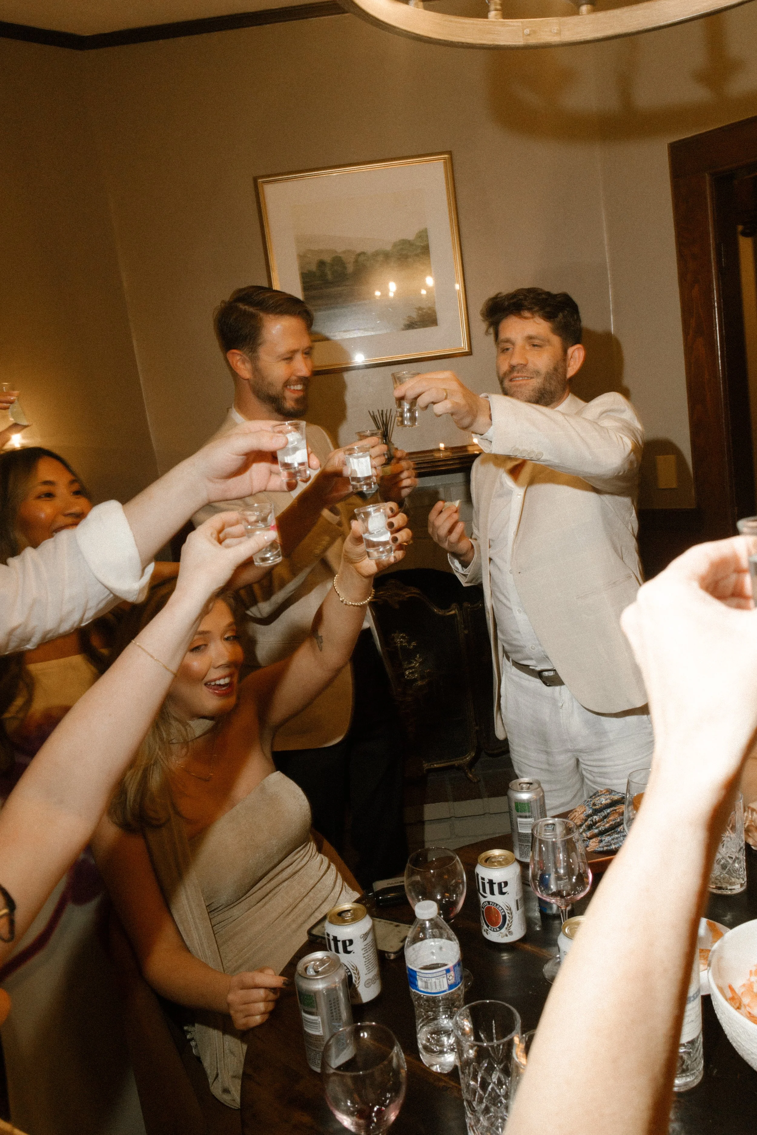 Guests raising tequila shots together in a celebratory toast during a lively wedding in Santa Barbara
