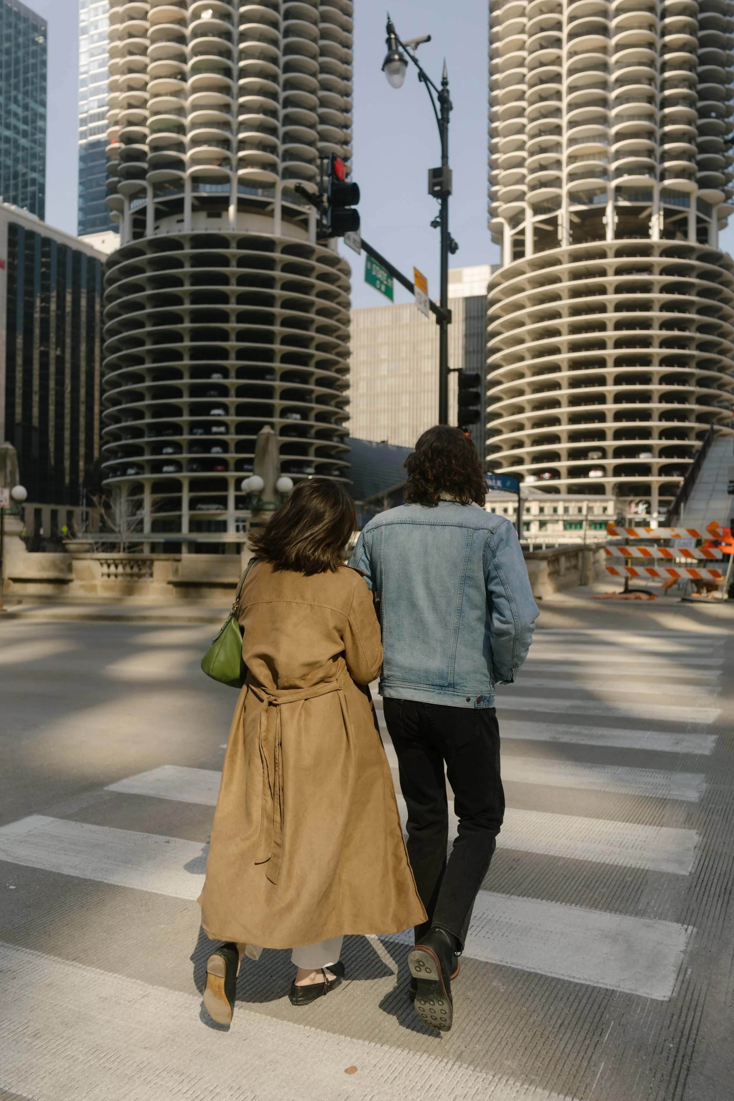 Couple walking away together across a crosswalk near Marina City towers in downtown Chicago during engagement photos in Chicago
