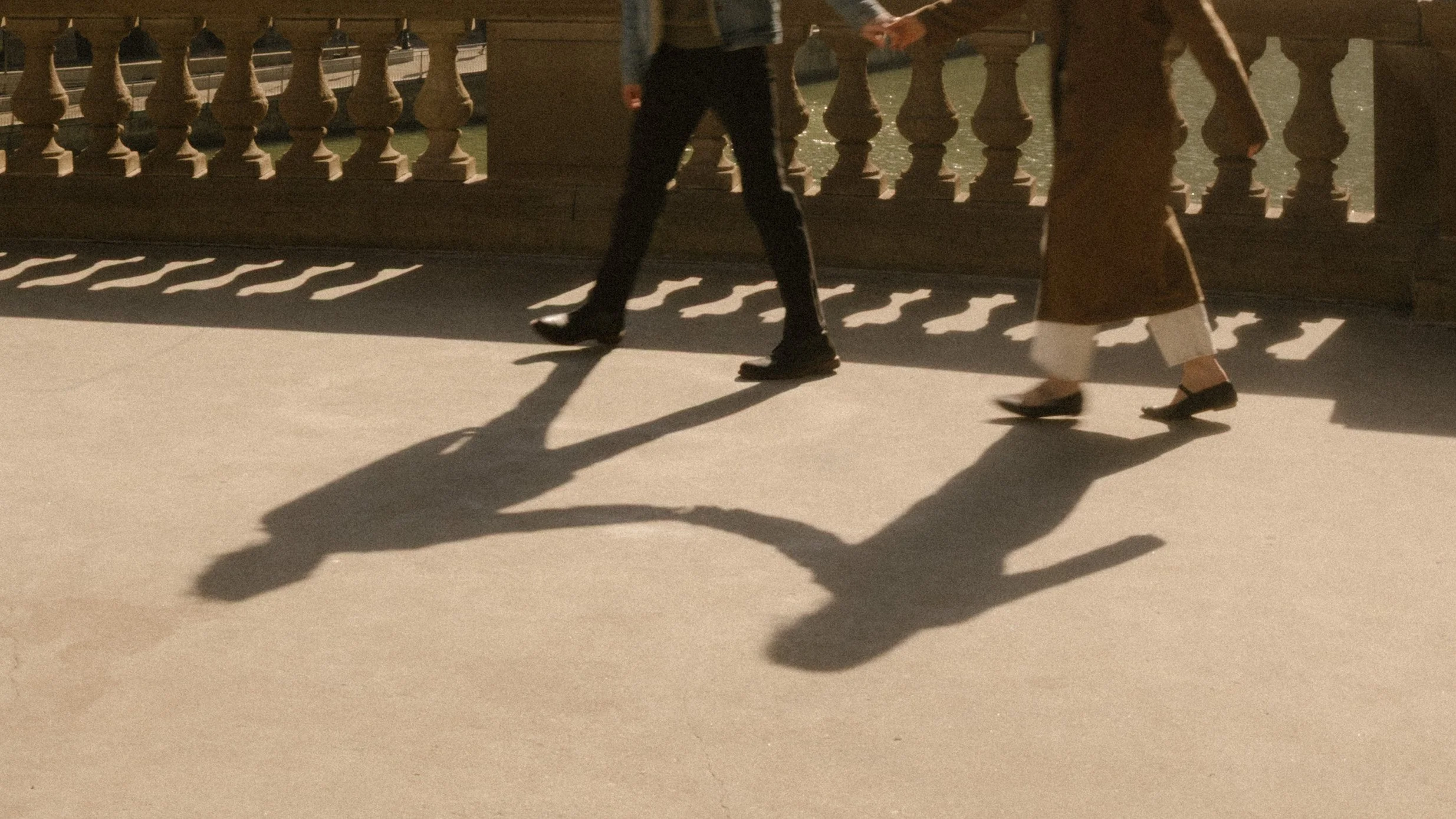 Detail shot of couple’s shadows holding hands and walking across a bridge during engagement photos in Chicago