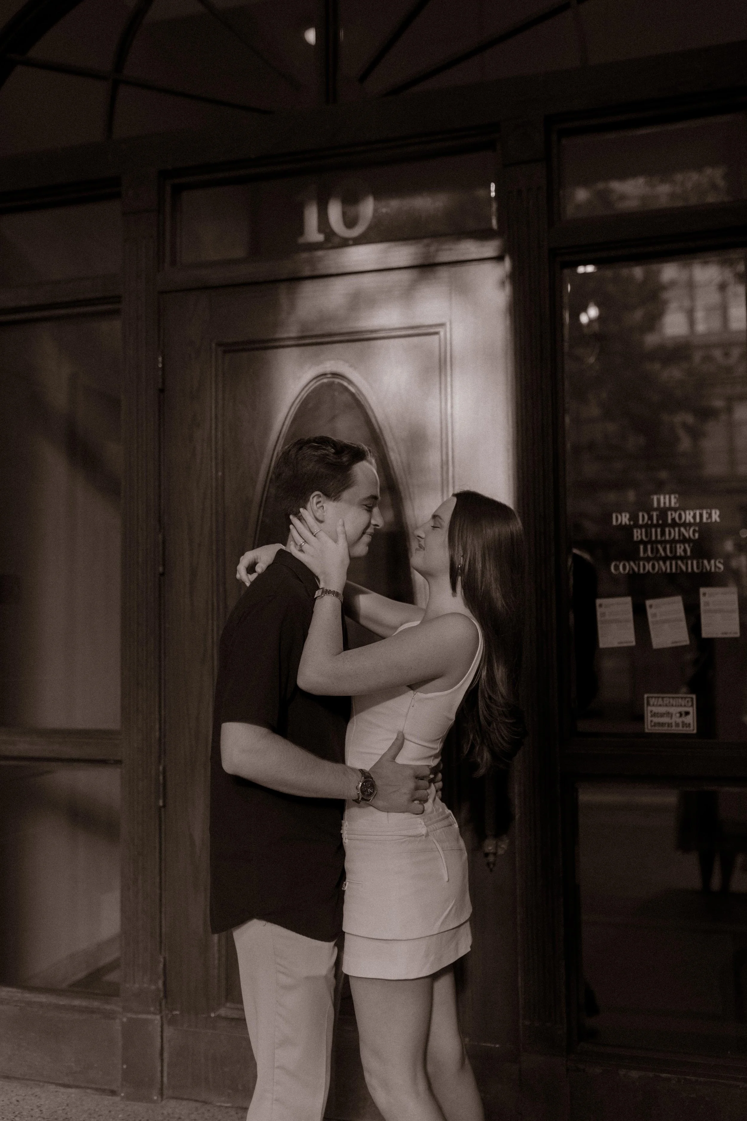 Black and white photo of couple embracing outside a historic building during new york city engagement photos