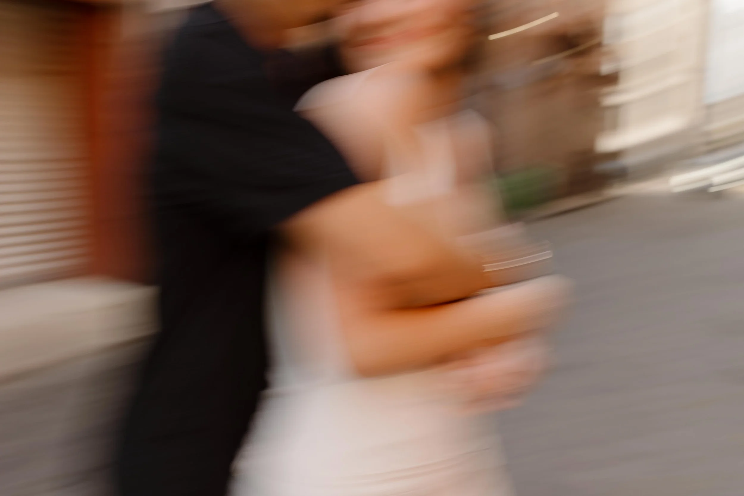 Intentional motion blur of couple embracing in a city street creating an artistic and editorial engagement photo