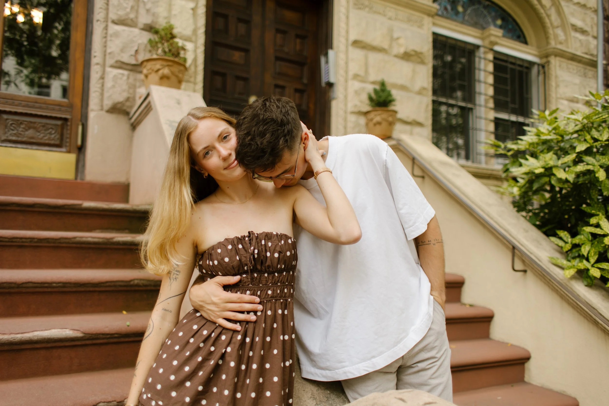 Couple embracing on a Brooklyn brownstone stoop during a relaxed New York City engagement session.