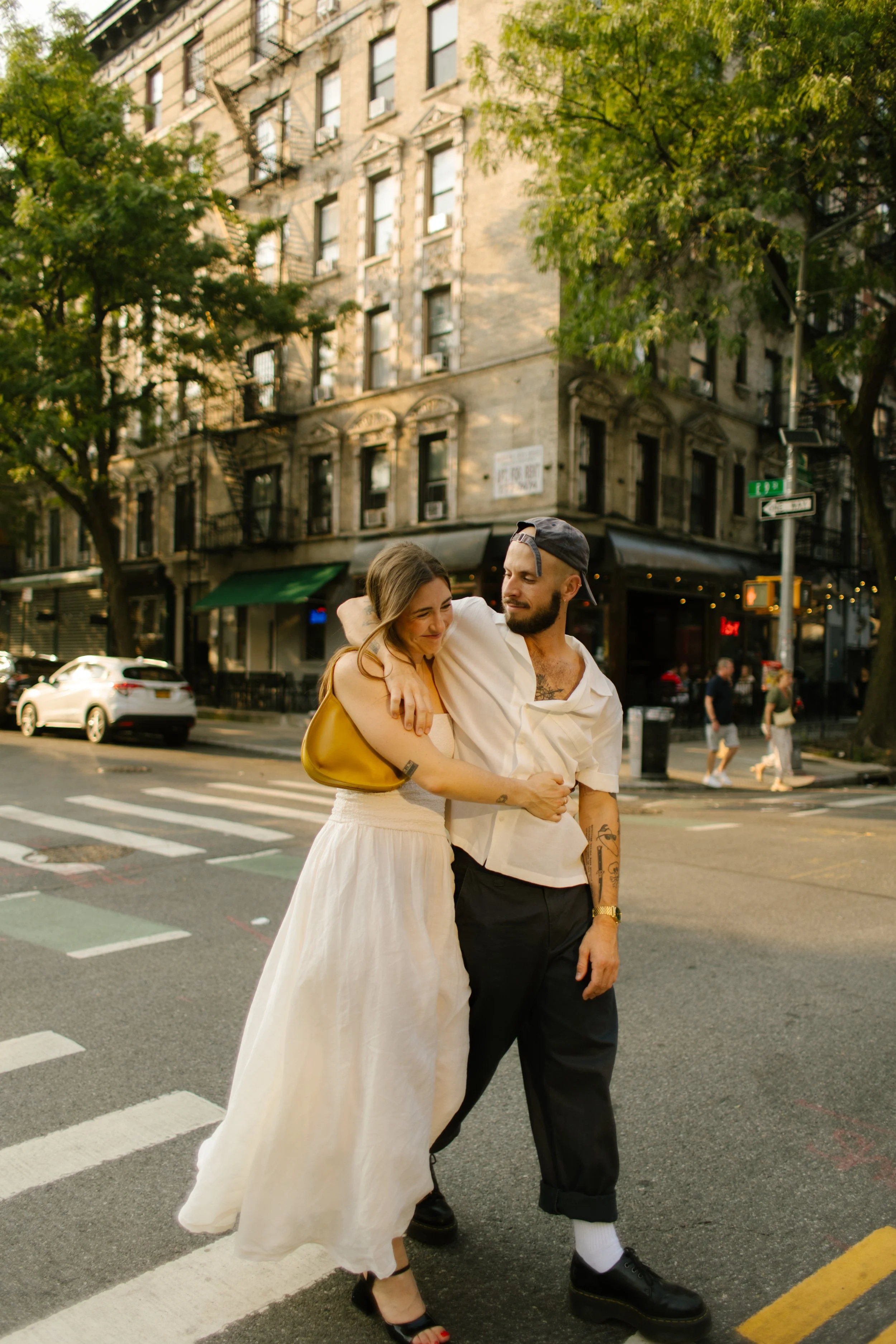 New York engagement photographer capturing a couple crossing a Manhattan street together during golden hour.