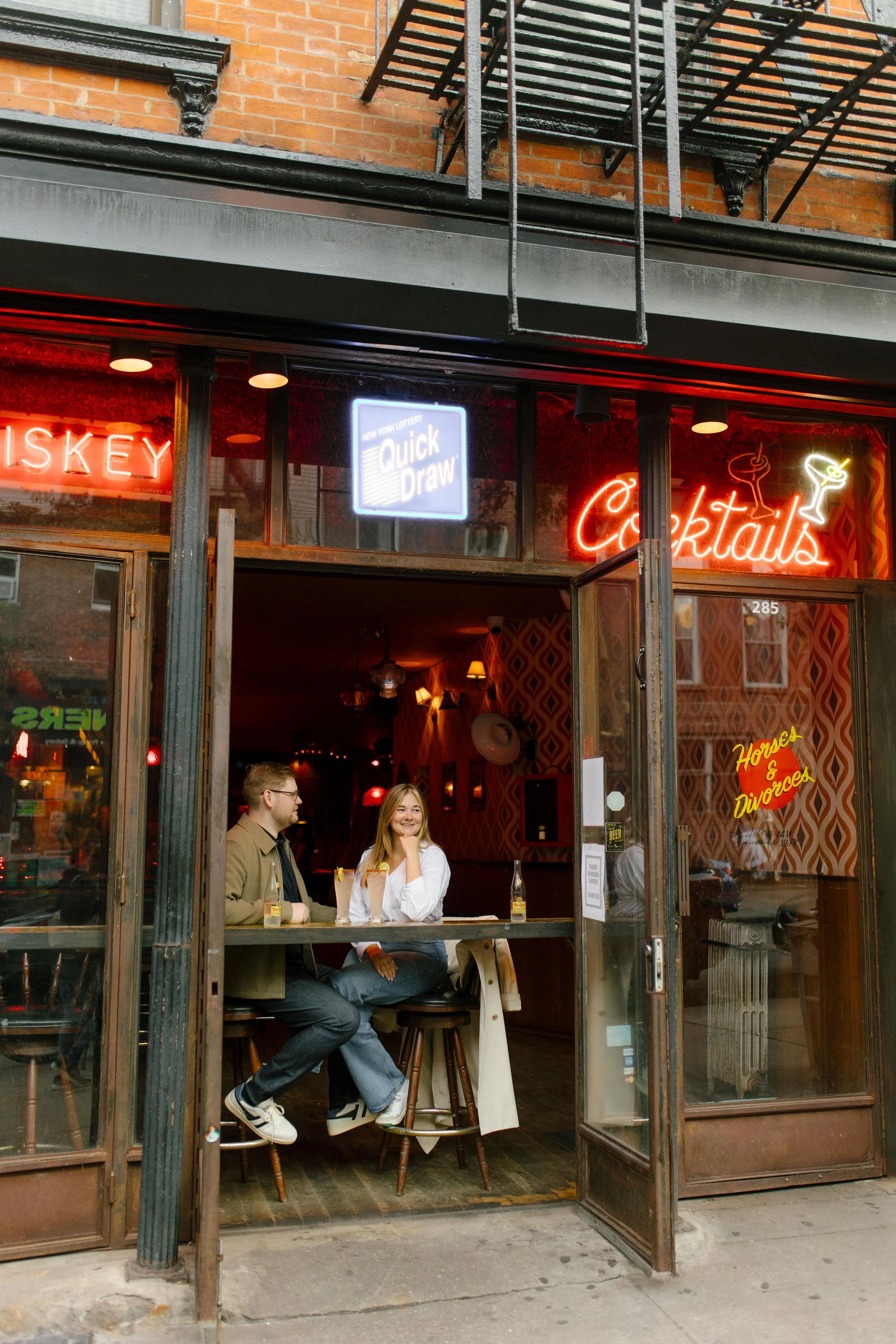 New York engagement photographer documenting a couple sharing drinks inside a cozy cocktail bar in Brooklyn.