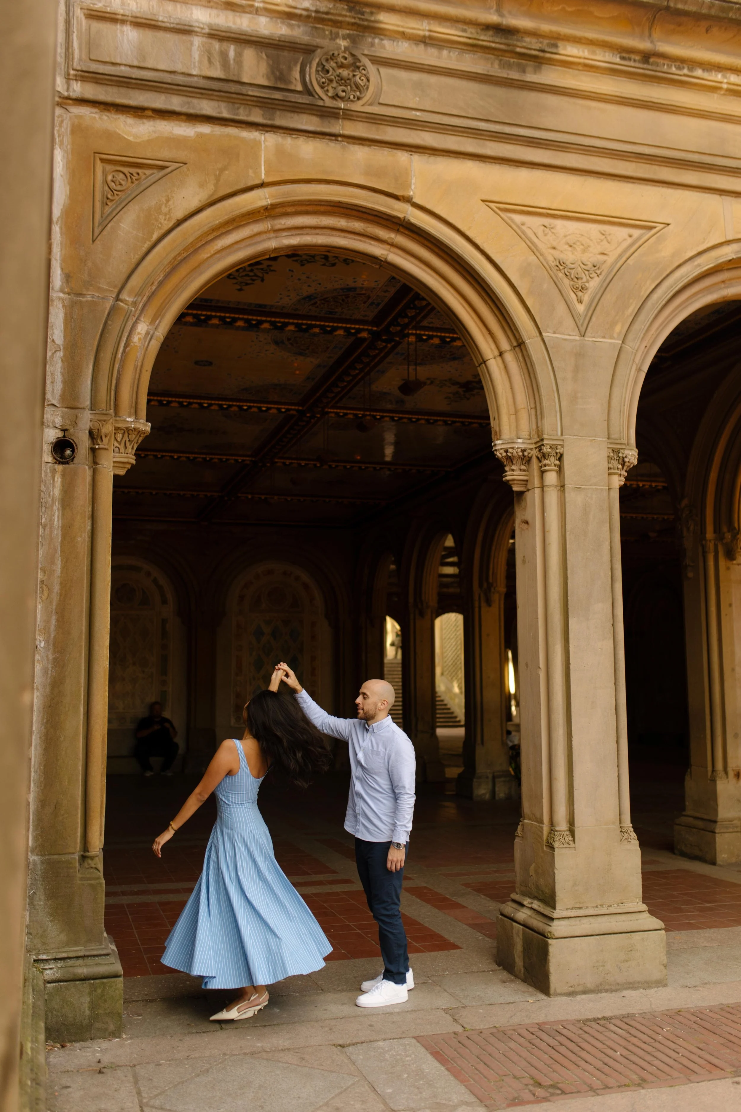 New York engagement photographer capturing a couple dancing beneath the Bethesda Terrace arches in Central Park.