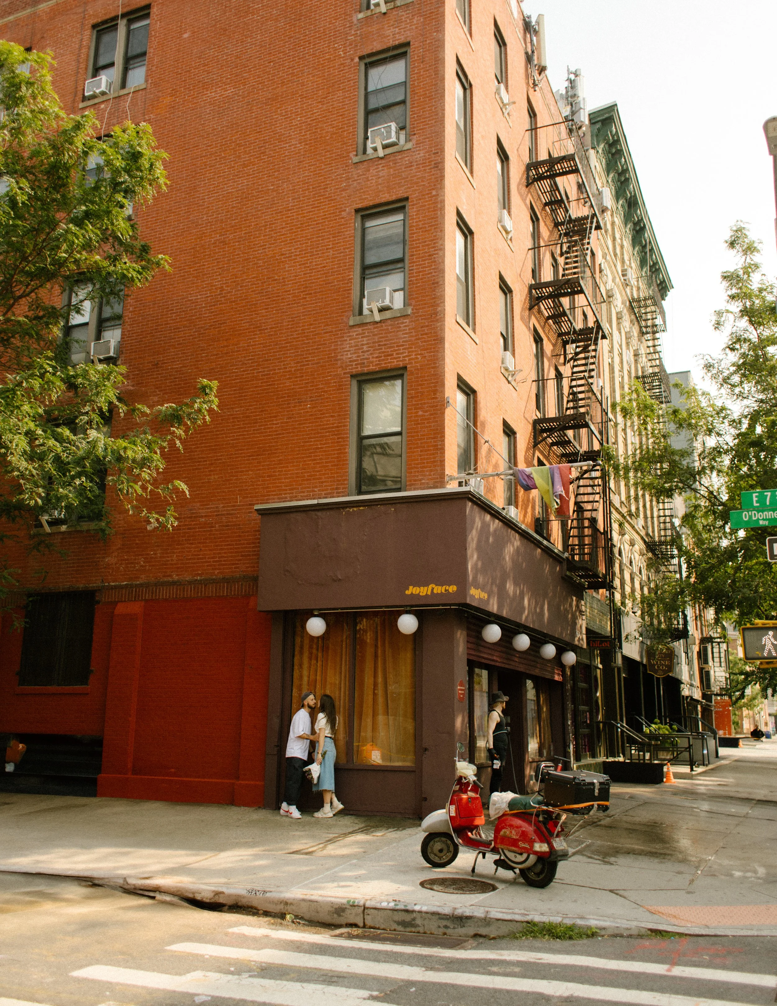 New York engagement photographer capturing a candid street corner portrait outside a neighborhood café in Manhattan.