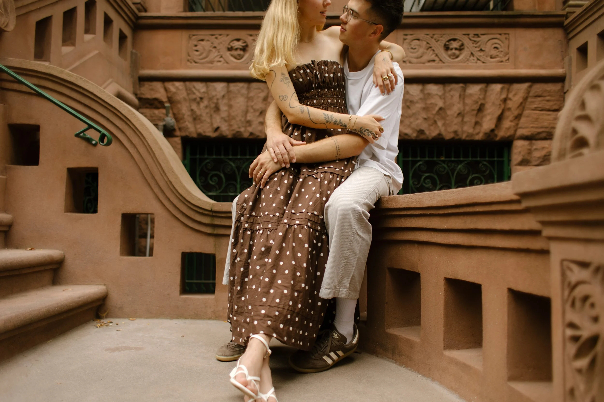 New York engagement photographer capturing an intimate seated portrait on a Brooklyn brownstone staircase.