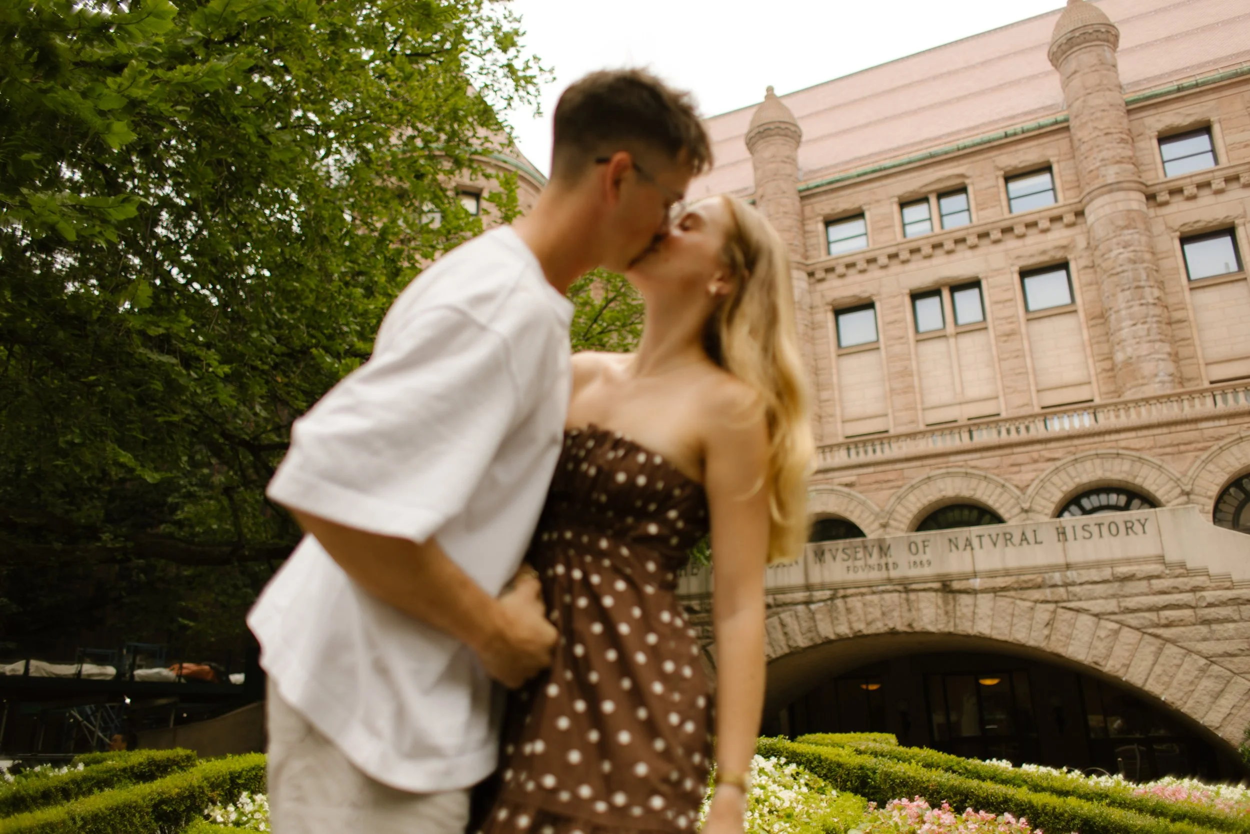 Couple kissing outside the American Museum of Natural History during a relaxed Upper West Side engagement session.